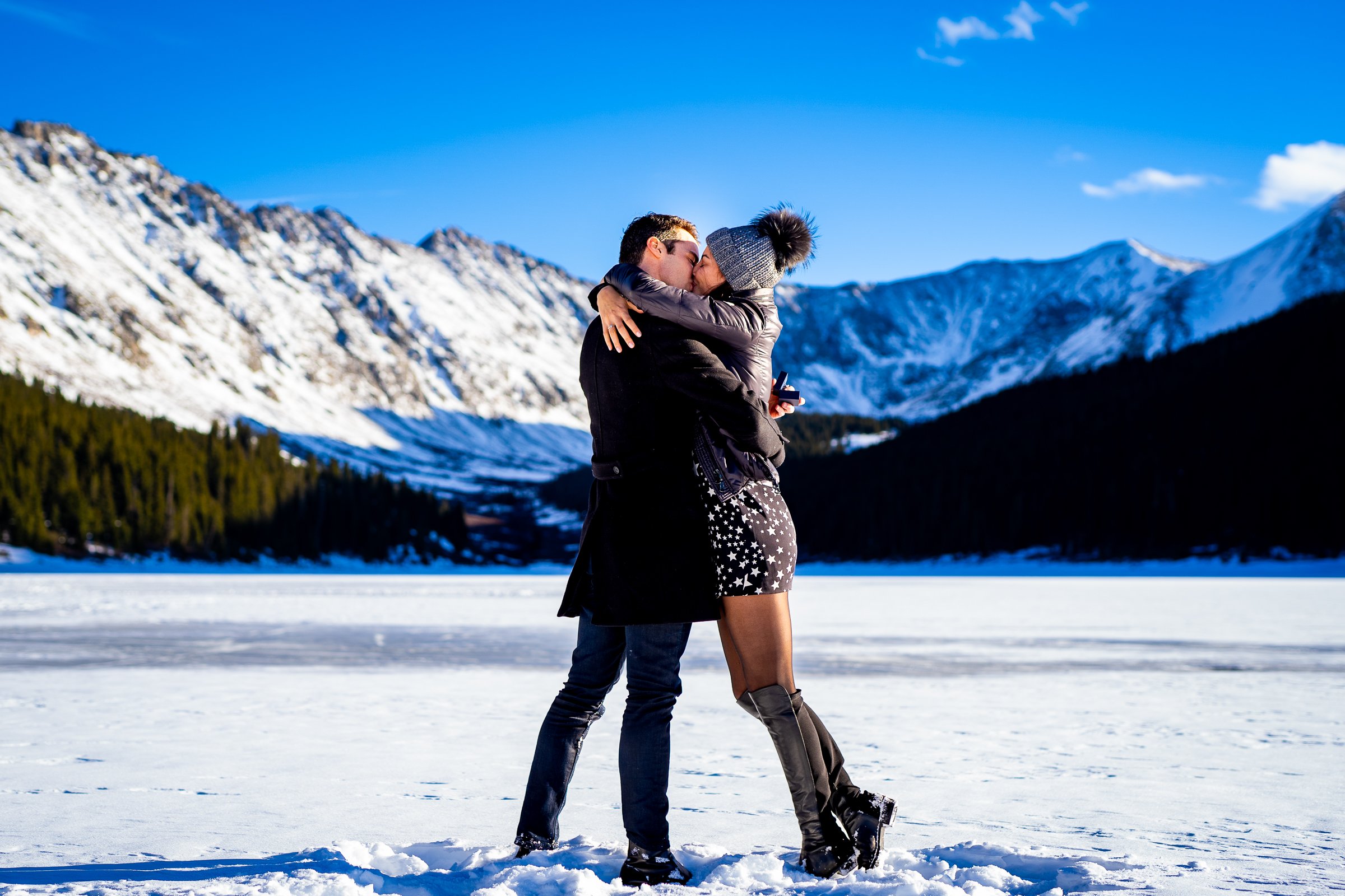 Man proposes to girlfriend while standing on a frozen lake with snowcapped mountains in the background, Engagement Session, Engagement Photos, Engagement Photos Inspiration, Engagement Photography, Engagement Photographer, Winter Engagement Photos, Proposal Photos, Proposal Photographer, Proposal Photography, Winter Proposal, Mountain Proposal, Proposal Inspiration, Summit County engagement session, Summit County engagement photos, Summit County engagement photography, Summit County engagement photographer, Summit County engagement inspiration, Colorado engagement session, Colorado engagement photos, Colorado engagement photography, Colorado engagement photographer, Colorado engagement inspiration, Clinton Gulch Engagement