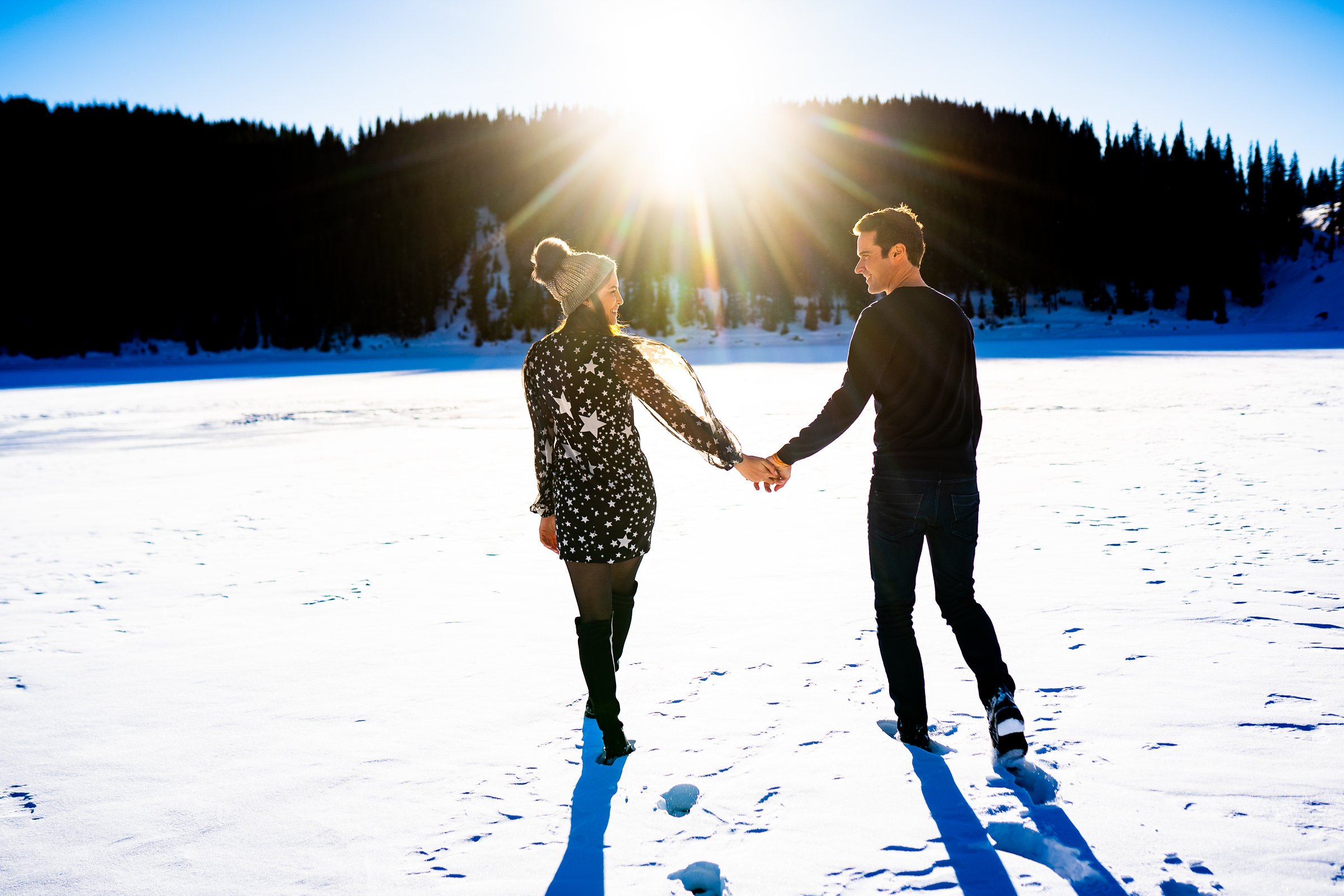 Newly engaged couple celebrate their proposal on a frozen lake with snowcapped mountains in the background, Engagement Session, Engagement Photos, Engagement Photos Inspiration, Engagement Photography, Engagement Photographer, Winter Engagement Photos, Proposal Photos, Proposal Photographer, Proposal Photography, Winter Proposal, Mountain Proposal, Proposal Inspiration, Summit County engagement session, Summit County engagement photos, Summit County engagement photography, Summit County engagement photographer, Summit County engagement inspiration, Colorado engagement session, Colorado engagement photos, Colorado engagement photography, Colorado engagement photographer, Colorado engagement inspiration, Clinton Gulch Engagement