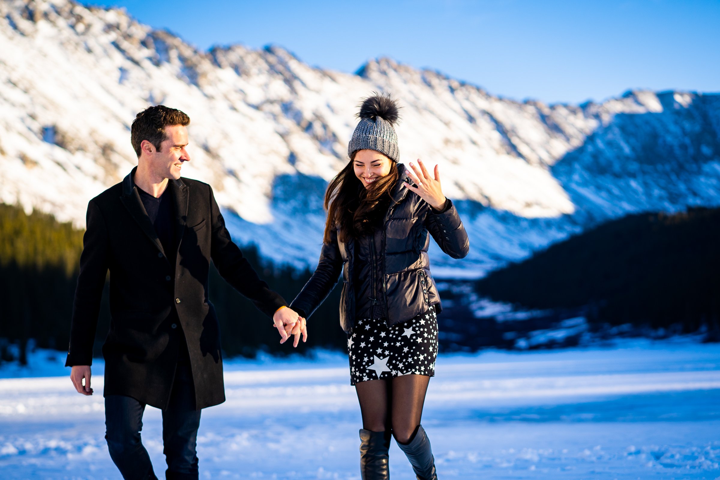Newly engaged couple celebrate their proposal on a frozen lake with snowcapped mountains in the background, Winter Engagement Session, Winter Engagement Photos, Engagement Photos Inspiration, Engagement Photography, Engagement Photographer, Winter Engagement Photos, Proposal Photos, Proposal Photographer, Proposal Photography, Winter Proposal, Mountain Proposal, Proposal Inspiration, Summit County engagement session, Summit County engagement photos, Summit County engagement photography, Summit County engagement photographer, Summit County engagement inspiration, Colorado engagement session, Colorado engagement photos, Colorado engagement photography, Colorado engagement photographer, Colorado engagement inspiration, Clinton Gulch Engagement