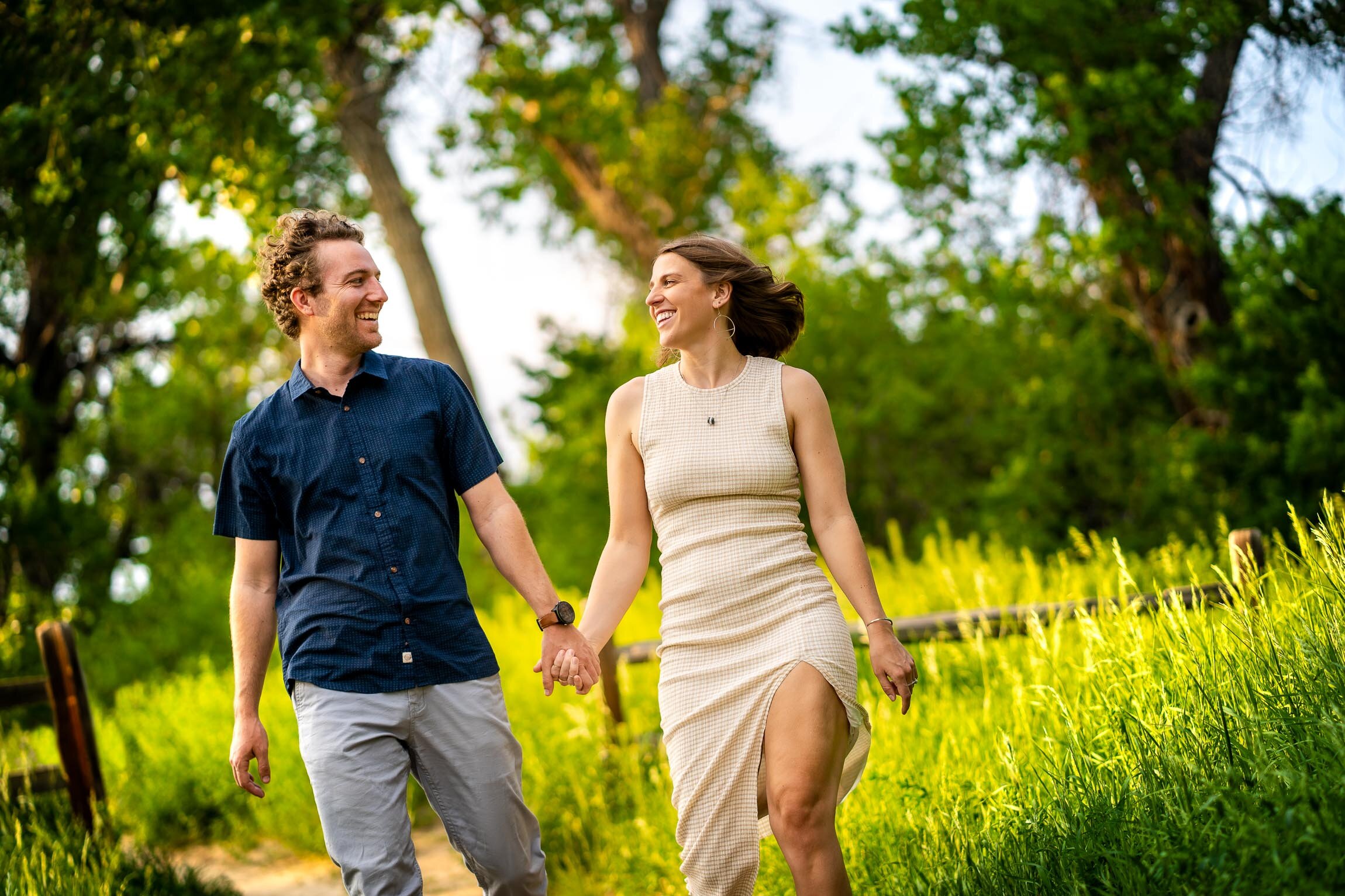 Engaged couple walks while holding hands in the tall windswept grass during golden hour, Engagement Session, Engagement Photos, Engagement Photos Inspiration, Engagement Photography, Engagement Photographer, Winter Engagement Photos, Mountain Engagement Photos, Denver engagement session, Denver engagement photos, Denver engagement photography, Denver engagement photographer, Denver engagement inspiration, Colorado engagement session, Colorado engagement photos, Colorado engagement photography, Colorado engagement photographer, Colorado engagement inspiration