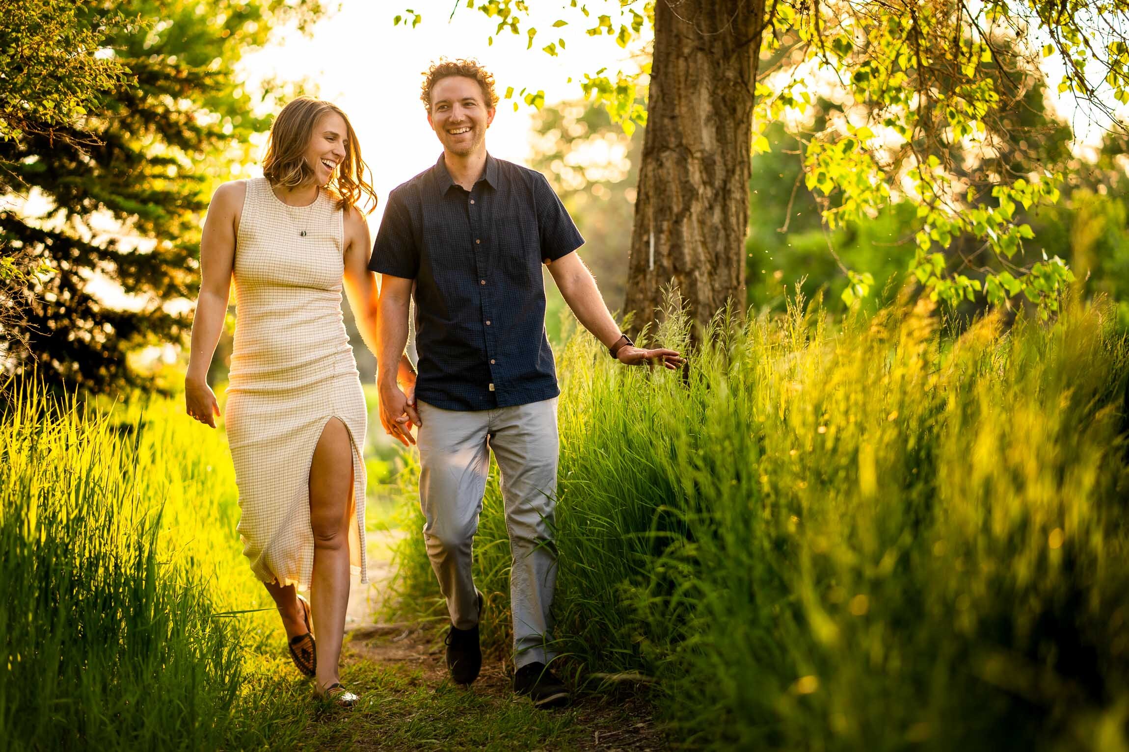 Engaged couple walks while holding hands in the tall windswept grass during golden hour, Engagement Session, Engagement Photos, Engagement Photos Inspiration, Engagement Photography, Engagement Photographer, Winter Engagement Photos, Mountain Engagement Photos, Denver engagement session, Denver engagement photos, Denver engagement photography, Denver engagement photographer, Denver engagement inspiration, Colorado engagement session, Colorado engagement photos, Colorado engagement photography, Colorado engagement photographer, Colorado engagement inspiration