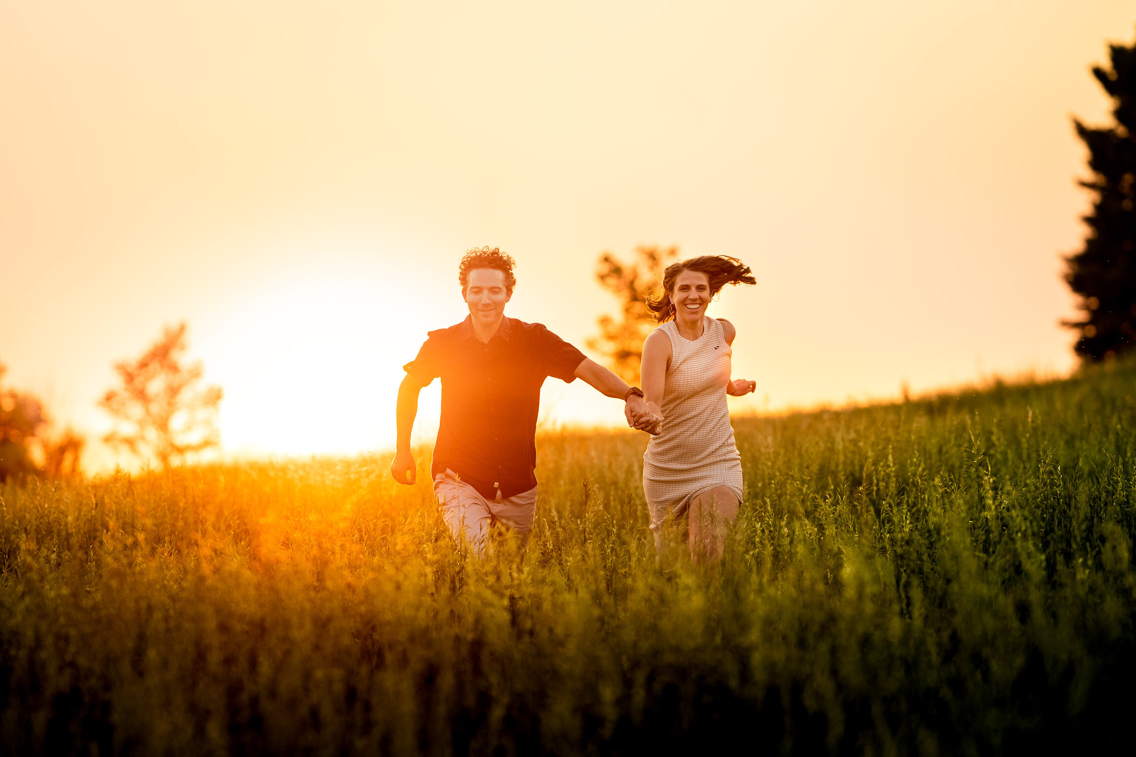 Engaged couple holds hands and runs through an open field of tall grass during golden hour, Engagement Session, Engagement Photos, Engagement Photos Inspiration, Engagement Photography, Engagement Photographer, Winter Engagement Photos, Mountain Engagement Photos, Denver engagement session, Denver engagement photos, Denver engagement photography, Denver engagement photographer, Denver engagement inspiration, Colorado engagement session, Colorado engagement photos, Colorado engagement photography, Colorado engagement photographer, Colorado engagement inspiration