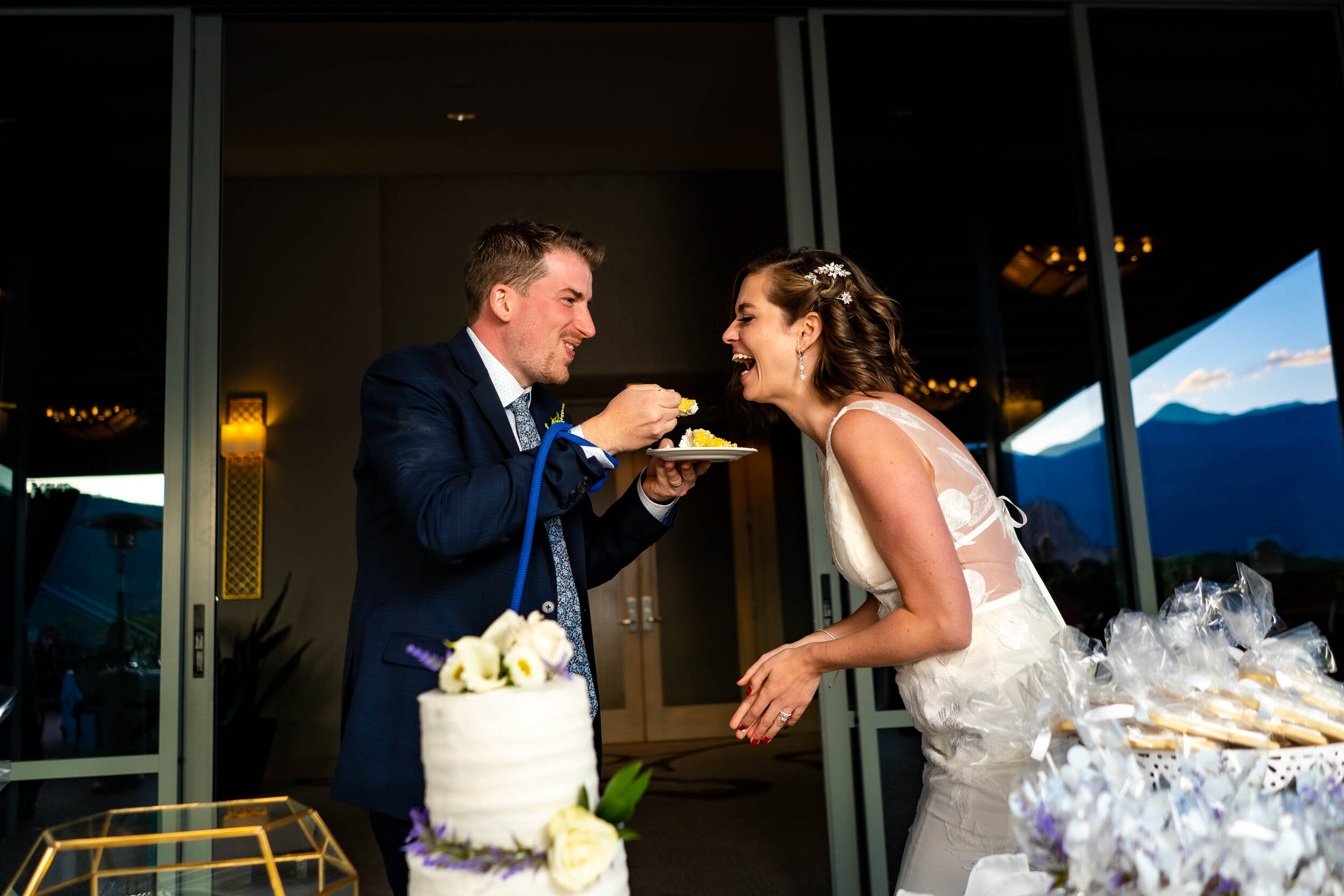 Bride and groom cut their wedding cake at the Garden of the Gods Club and resort by the reflection pond, wedding photos, wedding photography, wedding photographer, wedding inspiration, wedding photo inspiration, wedding portraits, wedding ceremony, wedding reception, mountain wedding, Garden of the Gods wedding, Garden of the Gods Club & Resort wedding, Garden of the Gods Club & Resort wedding photos, Garden of the Gods Club & Resort wedding photography, Garden of the Gods Club & Resort wedding photographer, Garden of the Gods Club & Resort wedding inspiration, Garden of the Gods Club & Resort wedding venue, Colorado Springs wedding, Colorado Springs wedding photos,  Colorado Springs wedding photography, Colorado Springs wedding photographer, Colorado wedding, Colorado wedding photos, Colorado wedding photography, Colorado wedding photographer, Colorado mountain wedding, Colorado wedding inspiration