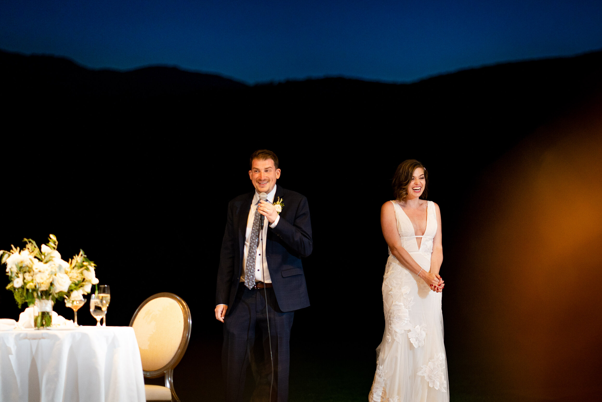 Bride and groom listen to speeches by family and friends during their wedding reception at the Garden of the Gods Club and resort by the reflection pond, wedding photos, wedding photography, wedding photographer, wedding inspiration, wedding photo inspiration, wedding portraits, wedding ceremony, wedding reception, mountain wedding, Garden of the Gods wedding, Garden of the Gods Club & Resort wedding, Garden of the Gods Club & Resort wedding photos, Garden of the Gods Club & Resort wedding photography, Garden of the Gods Club & Resort wedding photographer, Garden of the Gods Club & Resort wedding inspiration, Garden of the Gods Club & Resort wedding venue, Colorado Springs wedding, Colorado Springs wedding photos,  Colorado Springs wedding photography, Colorado Springs wedding photographer, Colorado wedding, Colorado wedding photos, Colorado wedding photography, Colorado wedding photographer, Colorado mountain wedding, Colorado wedding inspiration