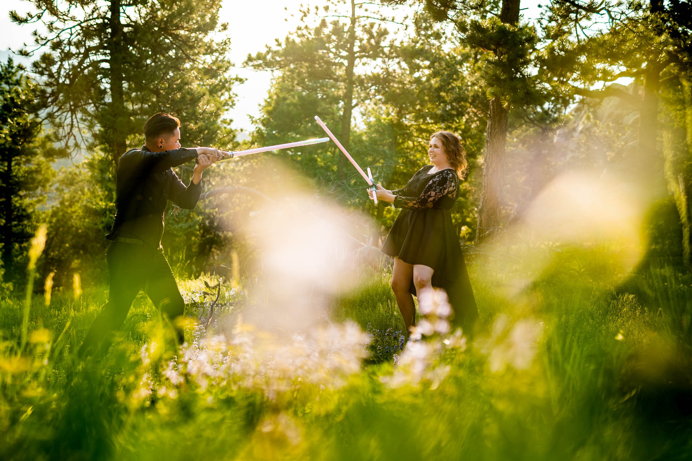 Engaged couple jumps into cosplay with their light sabers in the forest during golden hour, Engagement Session, Engagement Photos, Engagement Photos Inspiration, Engagement Photography, Engagement Photographer, Summer Engagement Photos, Mountain Engagement Photos, Lost Gulch Overlook engagement session, Lost Gulch Overlook engagement photos, Lost Gulch Overlook engagement photography, Lost Gulch Overlook engagement photographer, Lost Gulch Overlook  engagement inspiration, Boulder engagement session, Boulder engagement photos, Boulder engagement photography, Boulder engagement photographer, Boulder engagement inspiration, Colorado engagement session, Colorado engagement photos, Colorado engagement photography, Colorado engagement photographer, Colorado engagement inspiration