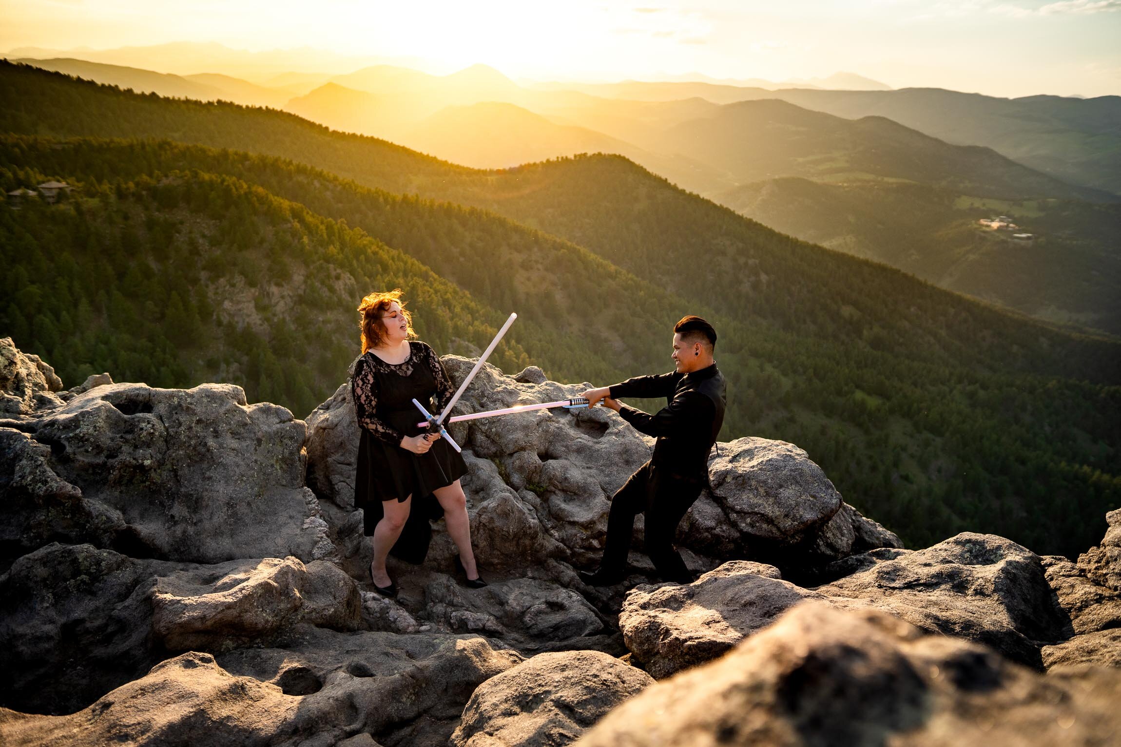 Engaged couple jumps into cosplay with their light sabers on a rocky ledge overlooking the mountains during golden hour, Engagement Session, Engagement Photos, Engagement Photos Inspiration, Engagement Photography, Engagement Photographer, Summer Engagement Photos, Mountain Engagement Photos, Lost Gulch Overlook engagement session, Lost Gulch Overlook engagement photos, Lost Gulch Overlook engagement photography, Lost Gulch Overlook engagement photographer, Lost Gulch Overlook  engagement inspiration, Boulder engagement session, Boulder engagement photos, Boulder engagement photography, Boulder engagement photographer, Boulder engagement inspiration, Colorado engagement session, Colorado engagement photos, Colorado engagement photography, Colorado engagement photographer, Colorado engagement inspiration