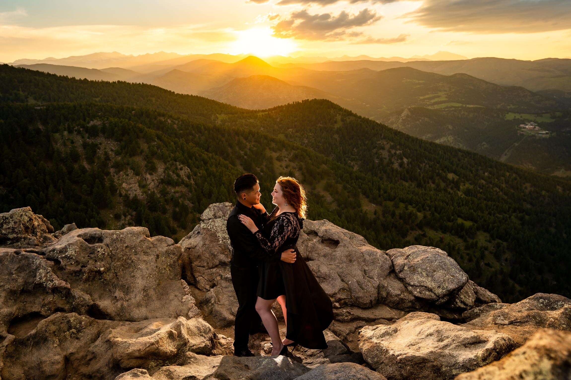 Engaged couple holds hands and watches the sun set from rocky ledge overlooking the mountains, Engagement Session, Sunset Engagement photos, Engagement Photos, Engagement Photos Inspiration, Engagement Photography, Engagement Photographer, Summer Engagement Photos, Mountain Engagement Photos, Lost Gulch Overlook engagement session, Lost Gulch Overlook engagement photos, Lost Gulch Overlook engagement photography, Lost Gulch Overlook engagement photographer, Lost Gulch Overlook  engagement inspiration, Boulder engagement session, Boulder engagement photos, Boulder engagement photography, Boulder engagement photographer, Boulder engagement inspiration, Colorado engagement session, Colorado engagement photos, Colorado engagement photography, Colorado engagement photographer, Colorado engagement inspiration