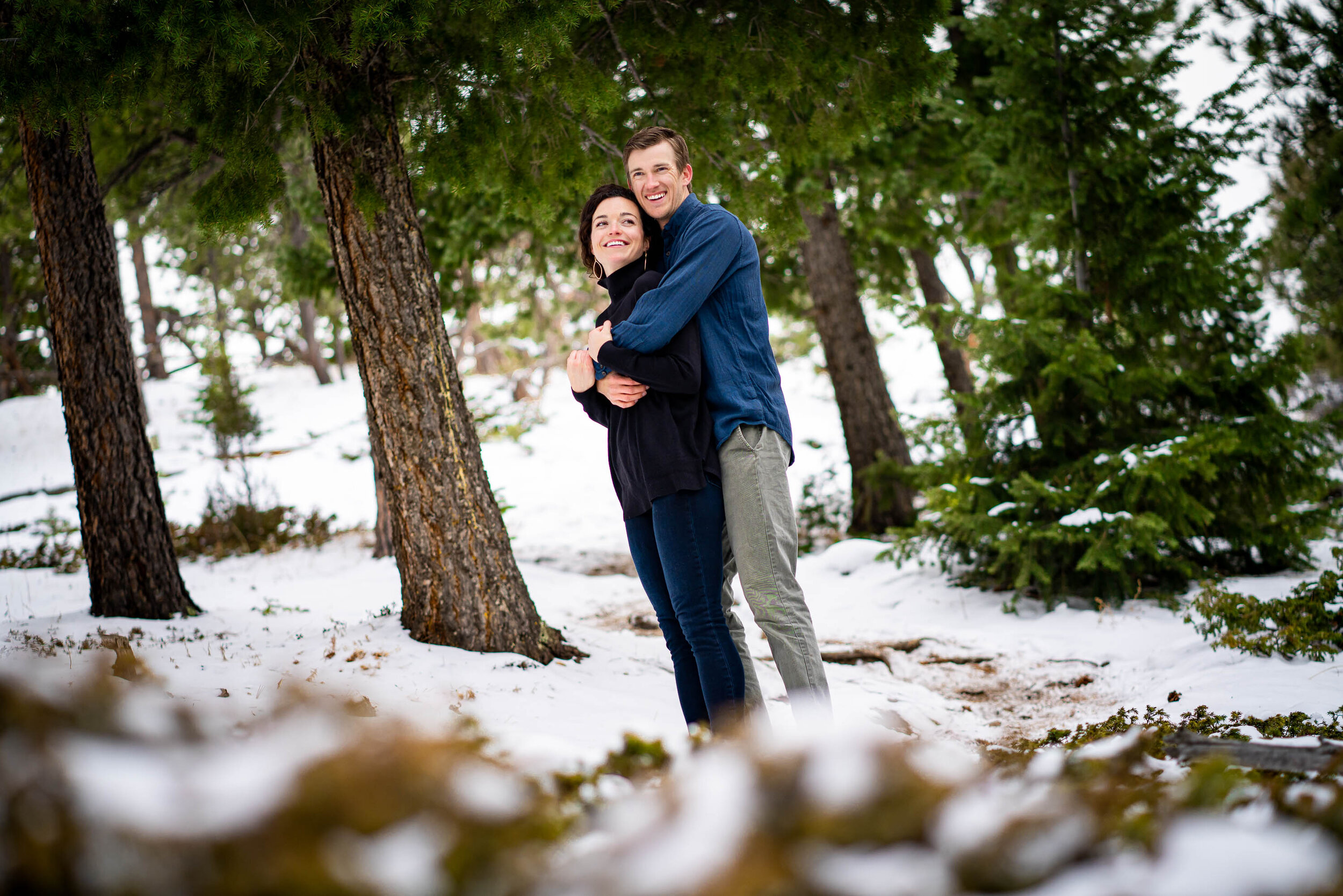 Engaged couple embraces in the snow in a dense evergreen mountain forest, Engagement Session, Engagement Photos, Engagement Photos Inspiration, Engagement Photography, Engagement Photographer, Winter Engagement Photos, Mountain Engagement Photos, Lost Gulch Overlook engagement session, Lost Gulch Overlook engagement photos, Lost Gulch Overlook engagement photography, Lost Gulch Overlook engagement photographer, Lost Gulch Overlook  engagement inspiration, Boulder engagement session, Boulder engagement photos, Boulder engagement photography, Boulder engagement photographer, Boulder engagement inspiration, Colorado engagement session, Colorado engagement photos, Colorado engagement photography, Colorado engagement photographer, Colorado engagement inspiration