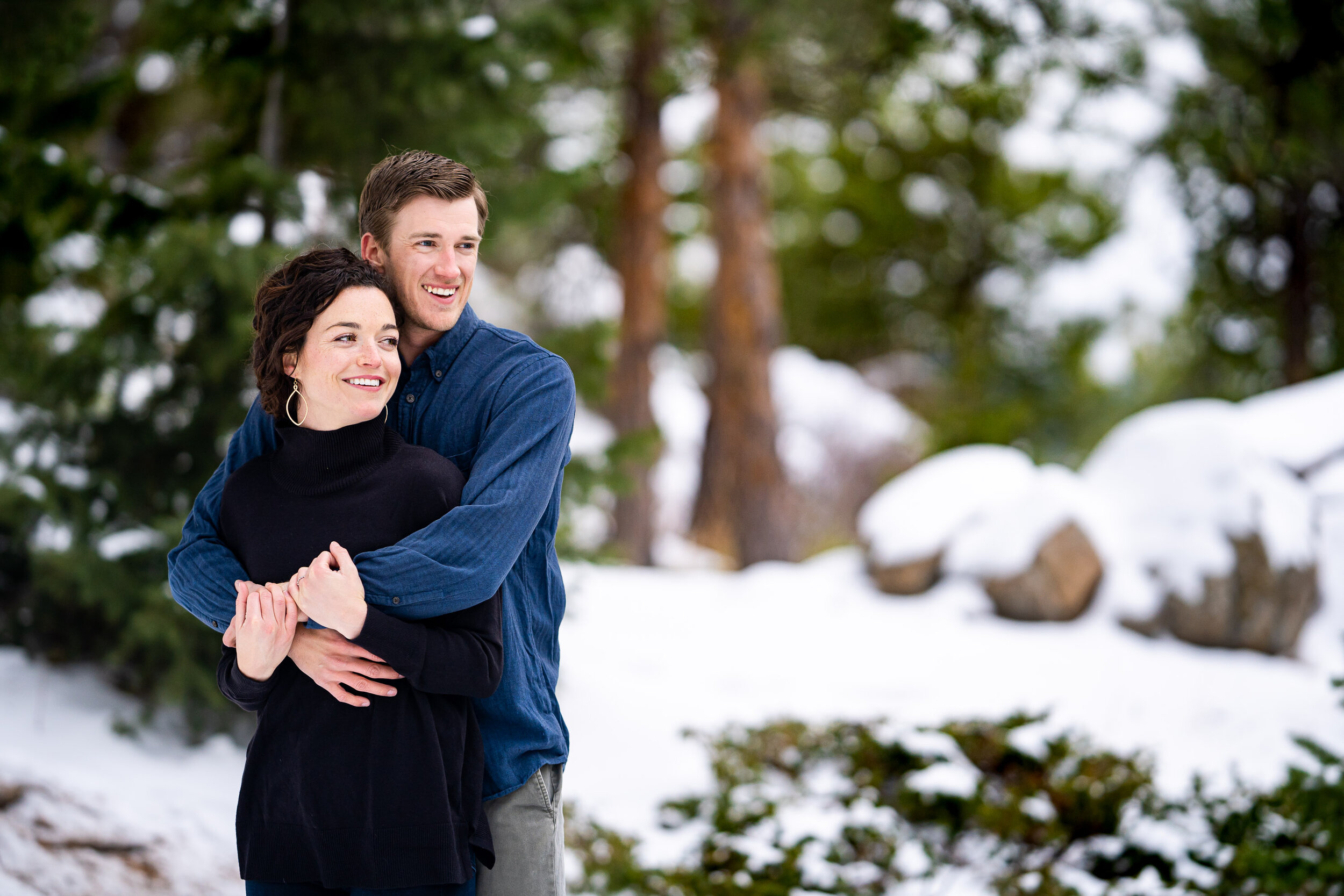 Engaged couple embraces in the snow in a dense evergreen mountain forest, Engagement Session, Engagement Photos, Engagement Photos Inspiration, Engagement Photography, Engagement Photographer, Winter Engagement Photos, Mountain Engagement Photos, Lost Gulch Overlook engagement session, Lost Gulch Overlook engagement photos, Lost Gulch Overlook engagement photography, Lost Gulch Overlook engagement photographer, Lost Gulch Overlook  engagement inspiration, Boulder engagement session, Boulder engagement photos, Boulder engagement photography, Boulder engagement photographer, Boulder engagement inspiration, Colorado engagement session, Colorado engagement photos, Colorado engagement photography, Colorado engagement photographer, Colorado engagement inspiration