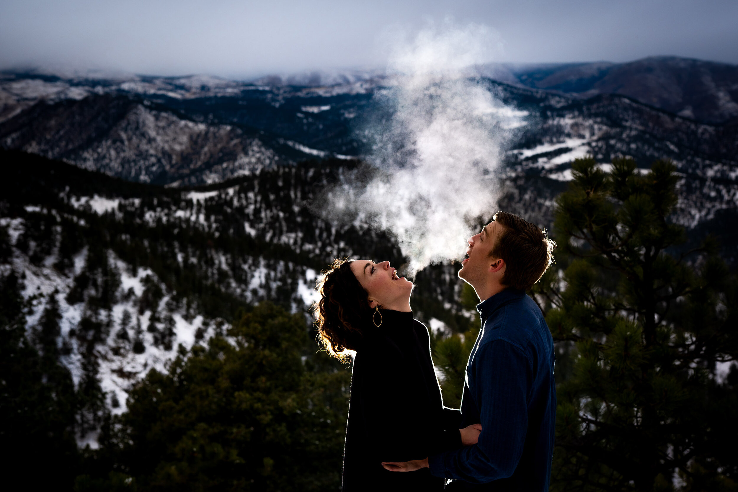 Engaged couple is backlit against the mountains at dusk in the winter, Engagement Session, Engagement Photos, Engagement Photos Inspiration, Engagement Photography, Engagement Photographer, Winter Engagement Photos, Mountain Engagement Photos, Lost Gulch Overlook engagement session, Lost Gulch Overlook engagement photos, Lost Gulch Overlook engagement photography, Lost Gulch Overlook engagement photographer, Lost Gulch Overlook  engagement inspiration, Boulder engagement session, Boulder engagement photos, Boulder engagement photography, Boulder engagement photographer, Boulder engagement inspiration, Colorado engagement session, Colorado engagement photos, Colorado engagement photography, Colorado engagement photographer, Colorado engagement inspiration