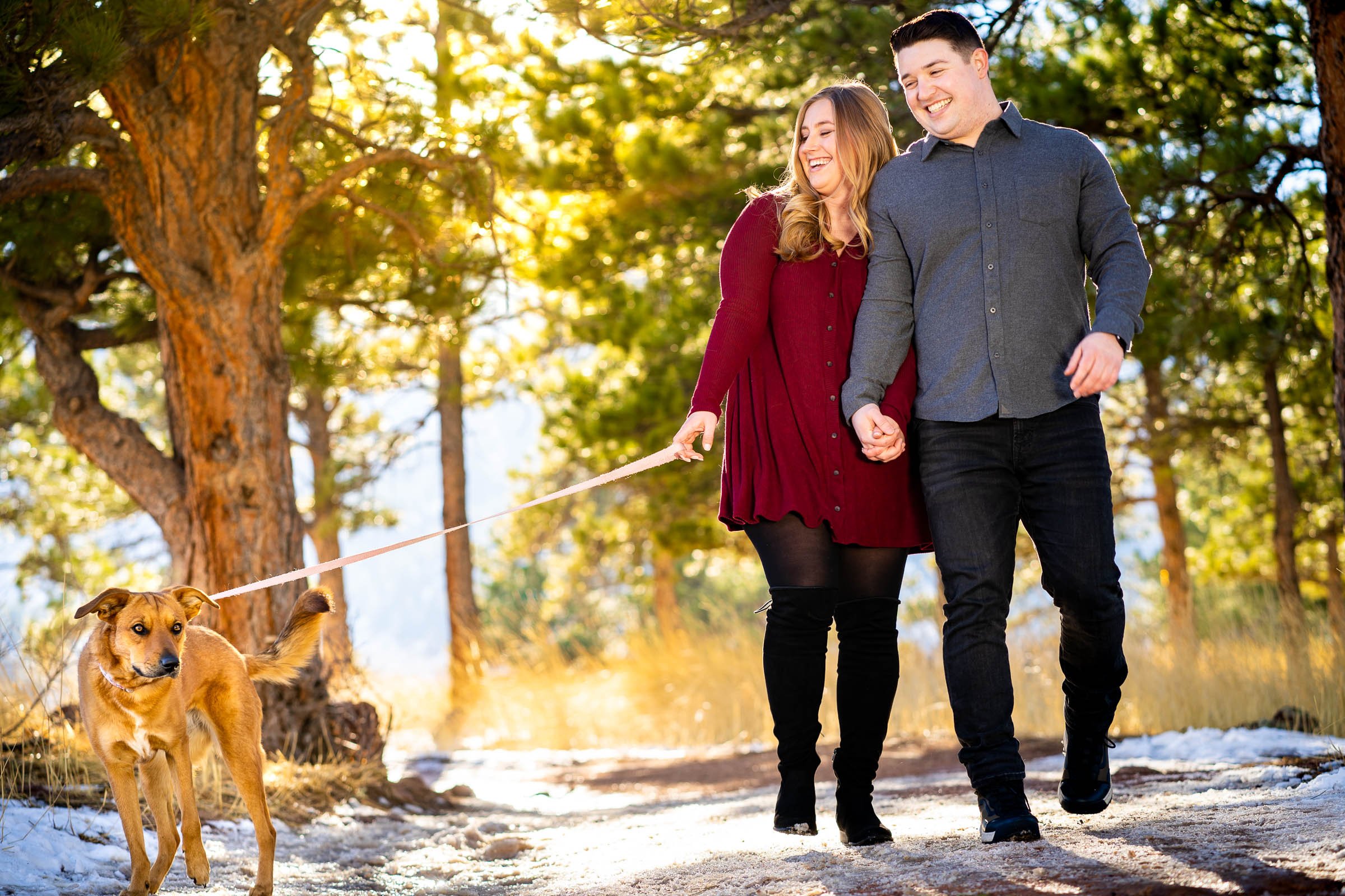 Couple walks with their dog during golden hour portraits with mountains in the background, Mountain Engagement Photos, Engagement Session, Engagement Photos, Engagement Photos Inspiration, Engagement Photography, Engagement Photographer, Engagement Portraits, Winter Engagement Photos, Snow Engagement Photos, Boulder engagement session, Boulder engagement photos, Boulder engagement photography, Boulder engagement photographer, Boulder engagement inspiration, NCAR Trail engagement session, NCAR Trail engagement photos, NCAR Trail engagement photography, NCAR Trail engagement photographer, NCAR Trail engagement inspiration, Colorado engagement session, Colorado engagement photos, Colorado engagement photography, Colorado engagement photographer, Colorado engagement inspiration