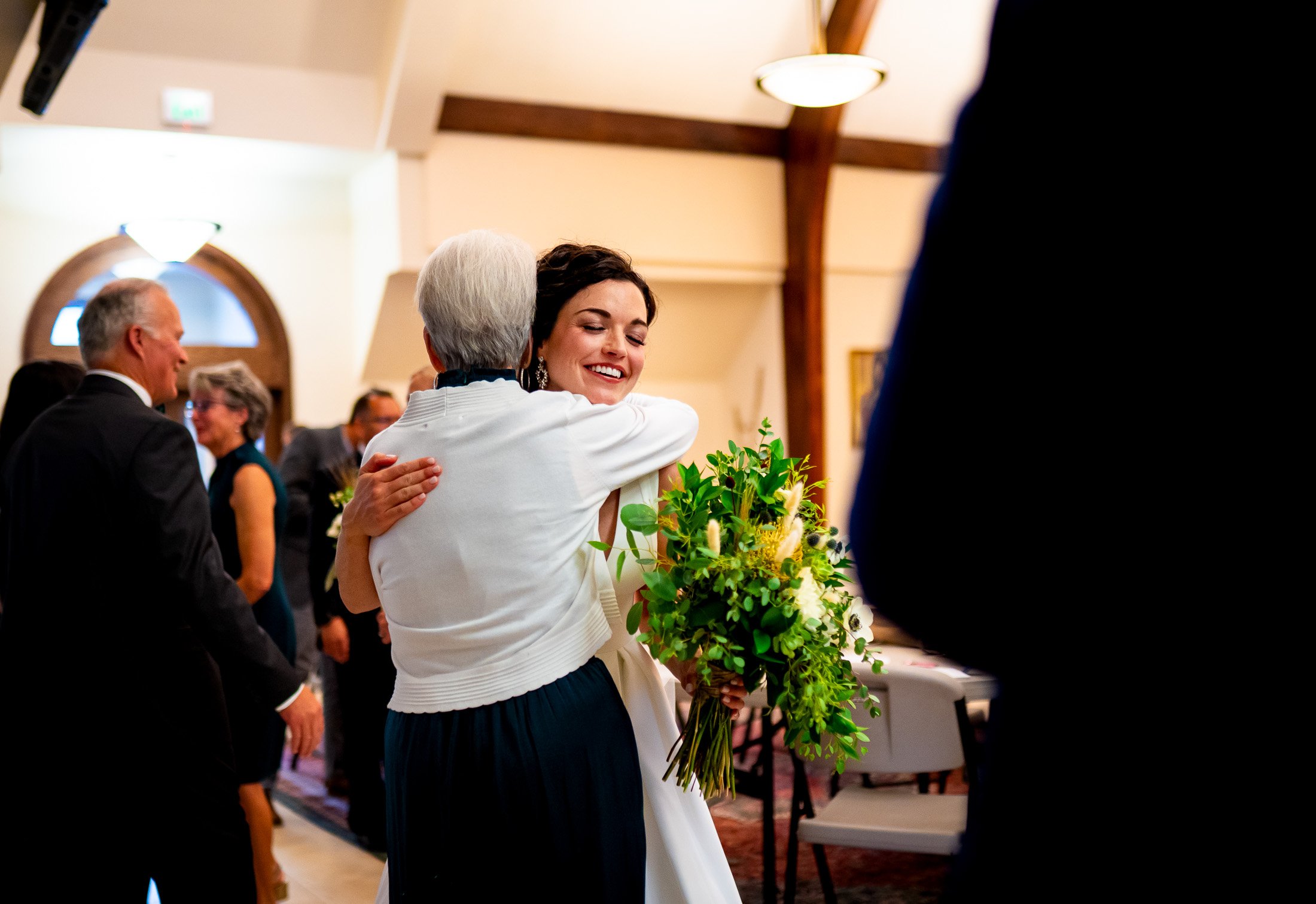 Bride hugs a guest after her catholic wedding ceremony at the church, wedding, wedding photos, wedding photography, wedding photographer, wedding inspiration, wedding photo inspiration, wedding portraits, wedding ceremony, wedding reception, mountain wedding, Catholic Church wedding, Catholic Church wedding photos, Catholic Church wedding photography, Catholic Church wedding photographer, Catholic Church wedding inspiration, Catholic Church wedding venue, Steamboat Springs wedding, Steamboat Springs wedding photos, Steamboat Springs wedding photography, Steamboat Springs wedding photographer, Colorado wedding, Colorado wedding photos, Colorado wedding photography, Colorado wedding photographer, Colorado mountain wedding, Colorado wedding inspiration