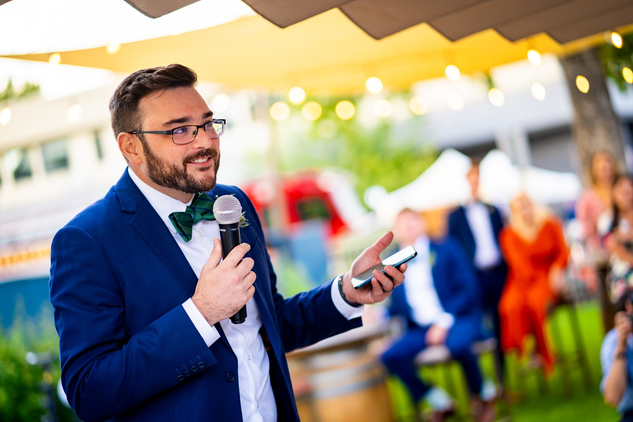 Best man gives a speech while standing on an outdoor patio during the wedding reception, wedding, wedding photos, wedding photography, wedding photographer, wedding inspiration, wedding photo inspiration, wedding portraits, wedding ceremony, wedding reception, mountain wedding, Catholic Church wedding, Catholic Church wedding photos, Catholic Church wedding photography, Catholic Church wedding photographer, Catholic Church wedding inspiration, Catholic Church wedding venue, Steamboat Springs wedding, Steamboat Springs wedding photos, Steamboat Springs wedding photography, Steamboat Springs wedding photographer, Colorado wedding, Colorado wedding photos, Colorado wedding photography, Colorado wedding photographer, Colorado mountain wedding, Colorado wedding inspiration