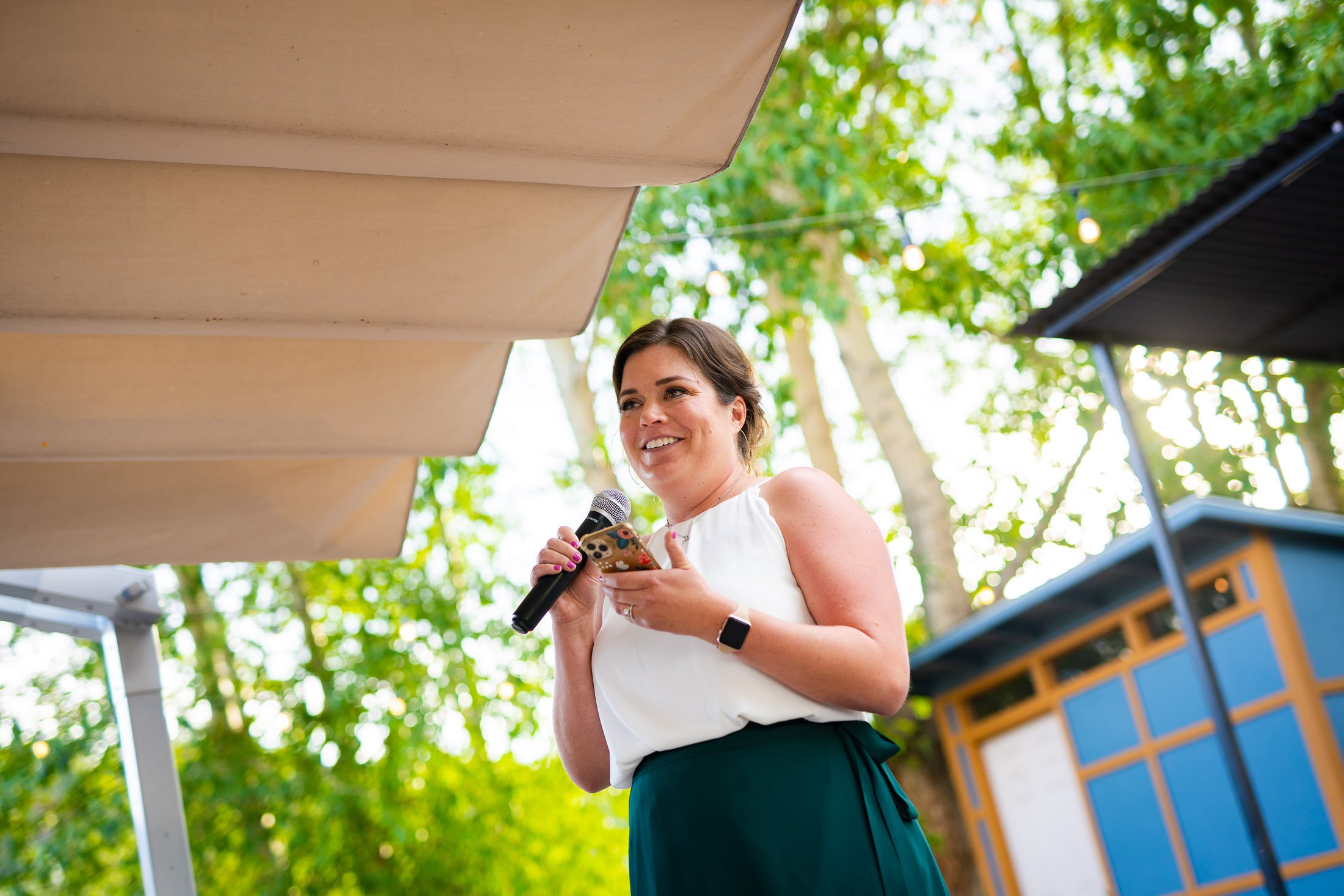 Maid of honor gives a speech while standing on an outdoor patio during the wedding reception, wedding, wedding photos, wedding photography, wedding photographer, wedding inspiration, wedding photo inspiration, wedding portraits, wedding ceremony, wedding reception, mountain wedding, Catholic Church wedding, Catholic Church wedding photos, Catholic Church wedding photography, Catholic Church wedding photographer, Catholic Church wedding inspiration, Catholic Church wedding venue, Steamboat Springs wedding, Steamboat Springs wedding photos, Steamboat Springs wedding photography, Steamboat Springs wedding photographer, Colorado wedding, Colorado wedding photos, Colorado wedding photography, Colorado wedding photographer, Colorado mountain wedding, Colorado wedding inspiration