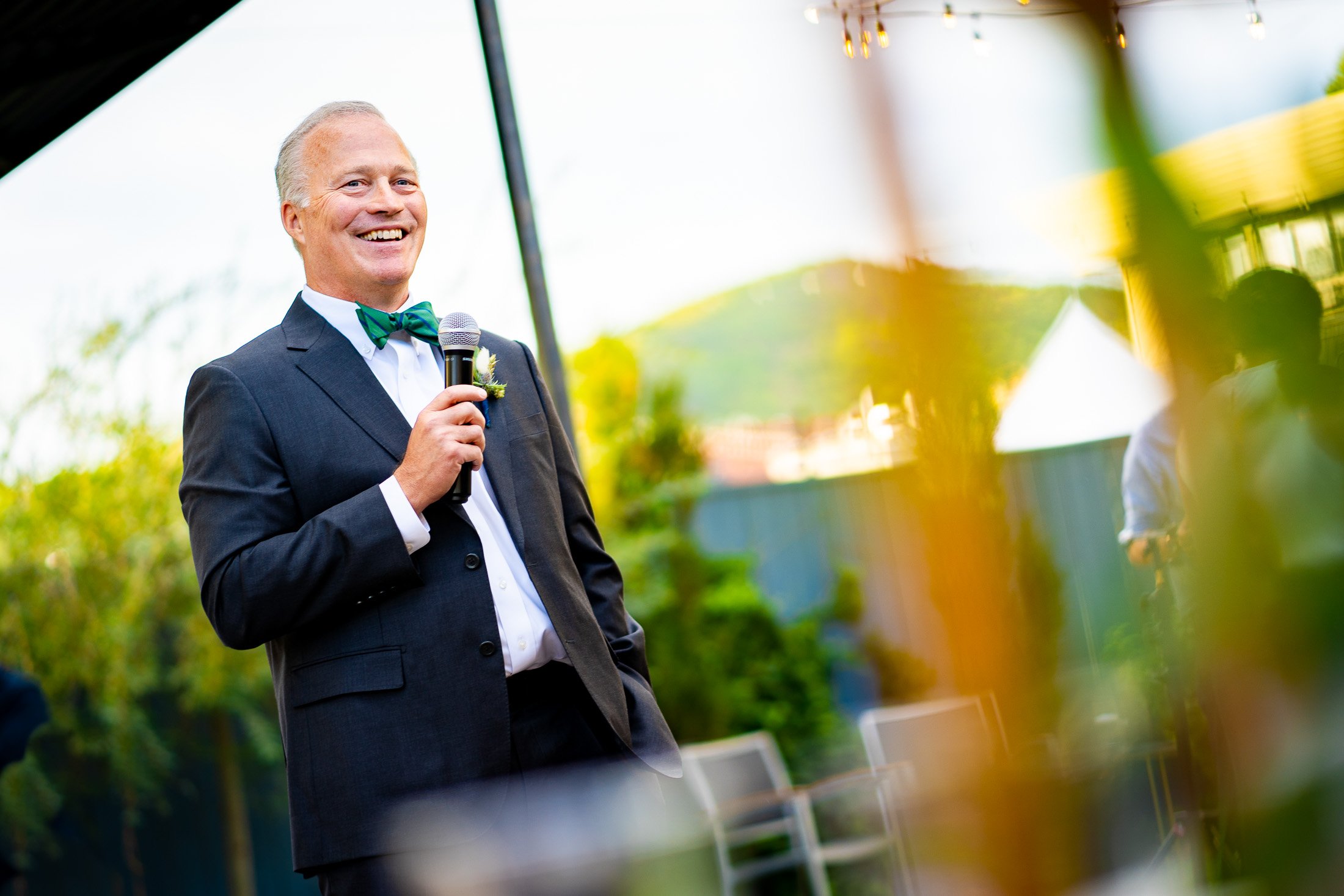 Father of the bride gives a speech while standing on an outdoor patio during the wedding reception, wedding, wedding photos, wedding photography, wedding photographer, wedding inspiration, wedding photo inspiration, wedding portraits, wedding ceremony, wedding reception, mountain wedding, Catholic Church wedding, Catholic Church wedding photos, Catholic Church wedding photography, Catholic Church wedding photographer, Catholic Church wedding inspiration, Catholic Church wedding venue, Steamboat Springs wedding, Steamboat Springs wedding photos, Steamboat Springs wedding photography, Steamboat Springs wedding photographer, Colorado wedding, Colorado wedding photos, Colorado wedding photography, Colorado wedding photographer, Colorado mountain wedding, Colorado wedding inspiration