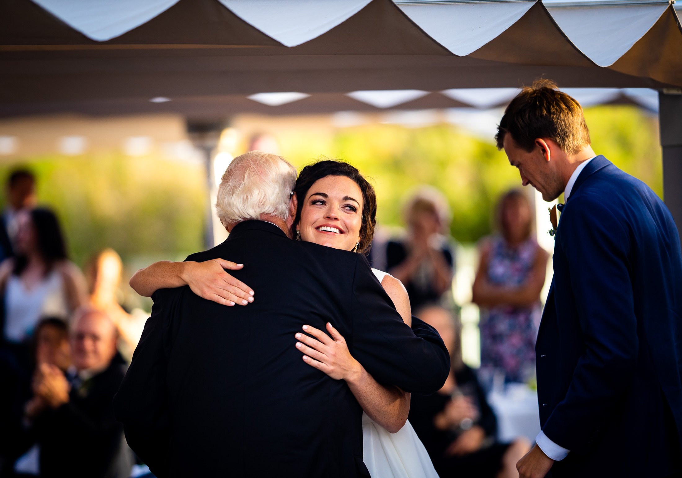 Bride and groom react to reception speeches while sitting on outdoor patio during the wedding reception, wedding, wedding photos, wedding photography, wedding photographer, wedding inspiration, wedding photo inspiration, wedding portraits, wedding ceremony, wedding reception, mountain wedding, Catholic Church wedding, Catholic Church wedding photos, Catholic Church wedding photography, Catholic Church wedding photographer, Catholic Church wedding inspiration, Catholic Church wedding venue, Steamboat Springs wedding, Steamboat Springs wedding photos, Steamboat Springs wedding photography, Steamboat Springs wedding photographer, Colorado wedding, Colorado wedding photos, Colorado wedding photography, Colorado wedding photographer, Colorado mountain wedding, Colorado wedding inspiration