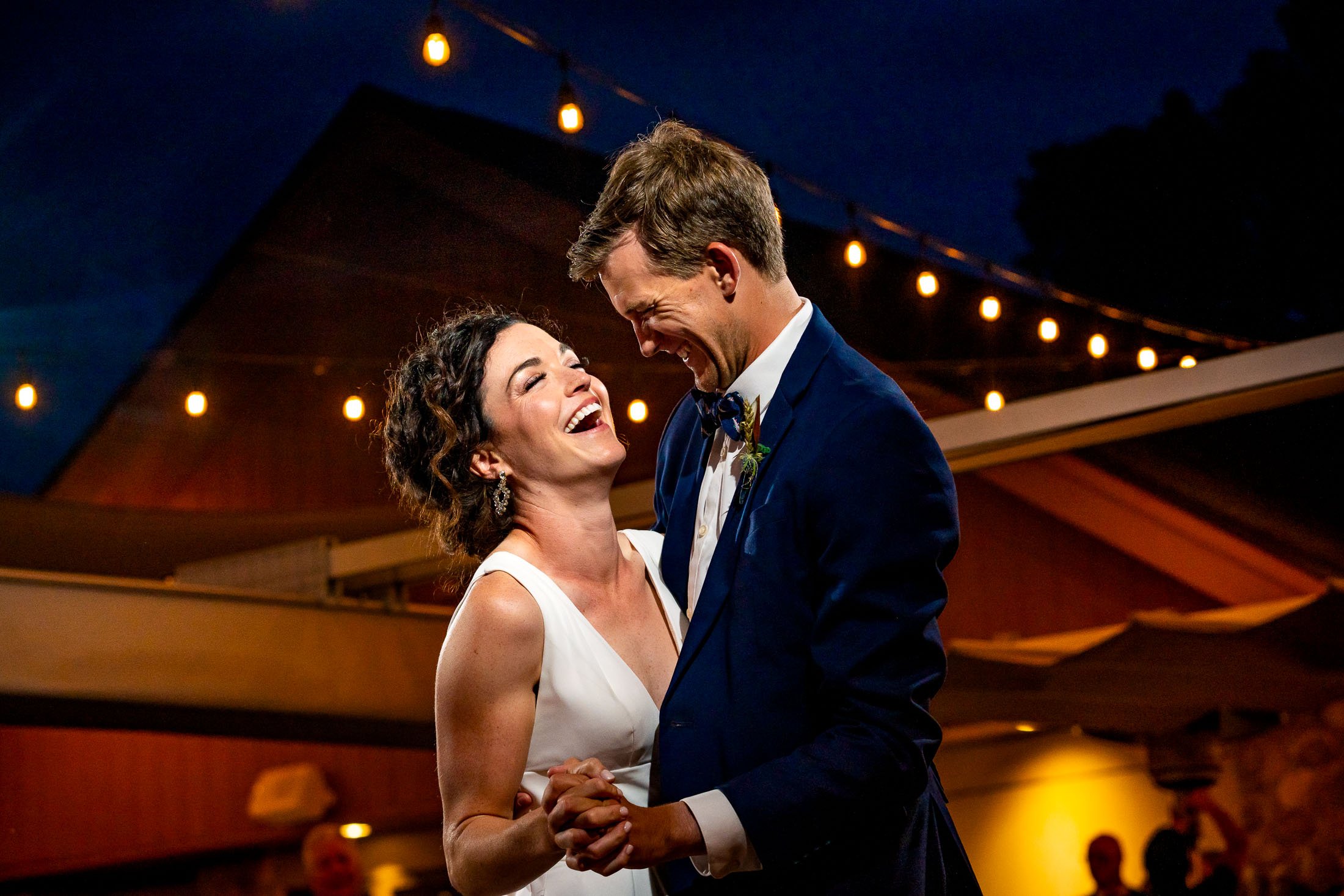 Bride and groom share their first dance on the outdoor patio under cafe lights at blue hour during their wedding reception, wedding, wedding photos, wedding photography, wedding photographer, wedding inspiration, wedding photo inspiration, wedding portraits, wedding ceremony, wedding reception, mountain wedding, Catholic Church wedding, Catholic Church wedding photos, Catholic Church wedding photography, Catholic Church wedding photographer, Catholic Church wedding inspiration, Catholic Church wedding venue, Steamboat Springs wedding, Steamboat Springs wedding photos, Steamboat Springs wedding photography, Steamboat Springs wedding photographer, Colorado wedding, Colorado wedding photos, Colorado wedding photography, Colorado wedding photographer, Colorado mountain wedding, Colorado wedding inspiration