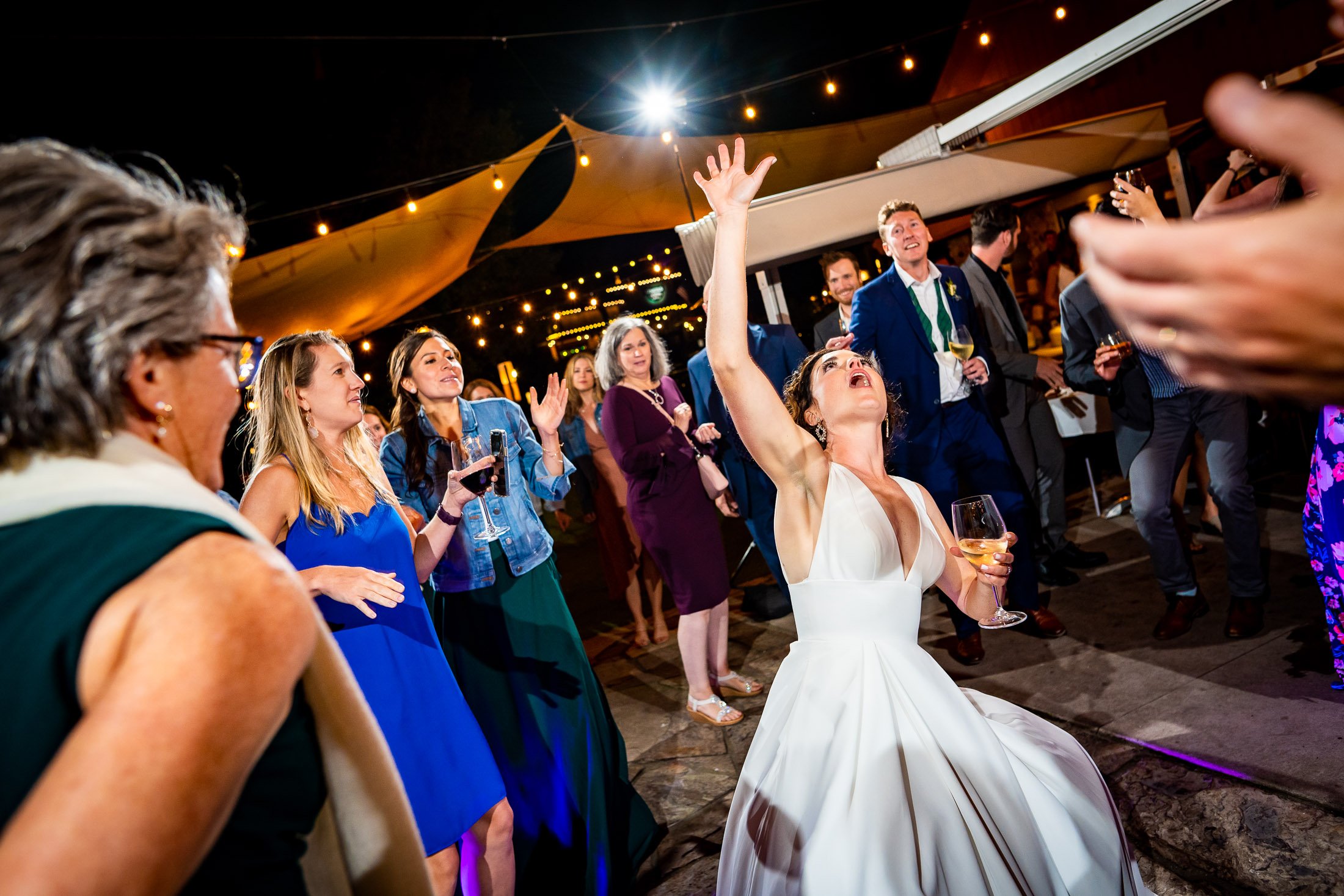 Guests dance to music on the outdoor patio under cafe lights during the wedding reception, wedding, wedding photos, wedding photography, wedding photographer, wedding inspiration, wedding photo inspiration, wedding portraits, wedding ceremony, wedding reception, mountain wedding, Catholic Church wedding, Catholic Church wedding photos, Catholic Church wedding photography, Catholic Church wedding photographer, Catholic Church wedding inspiration, Catholic Church wedding venue, Steamboat Springs wedding, Steamboat Springs wedding photos, Steamboat Springs wedding photography, Steamboat Springs wedding photographer, Colorado wedding, Colorado wedding photos, Colorado wedding photography, Colorado wedding photographer, Colorado mountain wedding, Colorado wedding inspiration