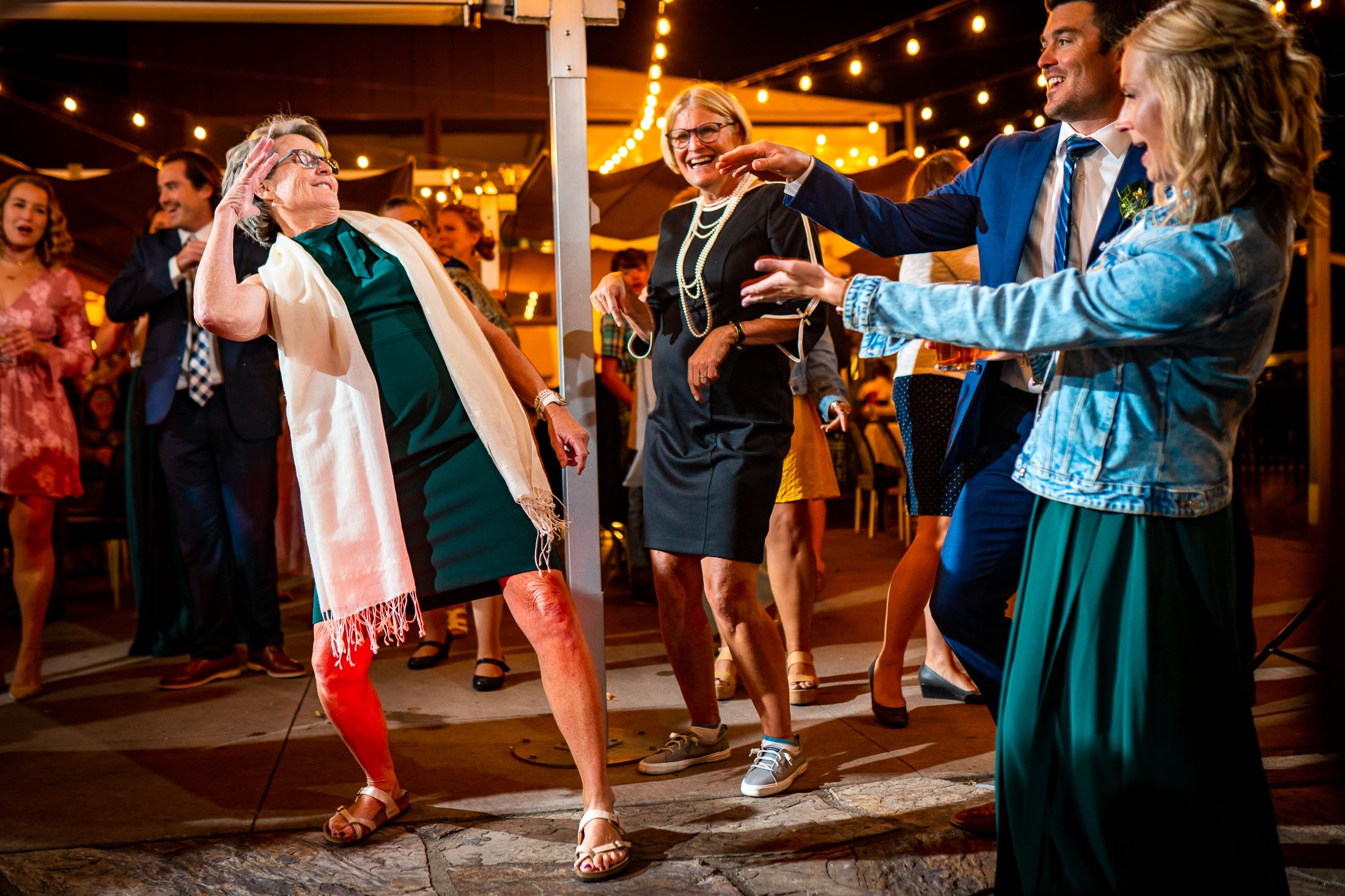 Guests dance to music on the outdoor patio under cafe lights during the wedding reception, wedding, wedding photos, wedding photography, wedding photographer, wedding inspiration, wedding photo inspiration, wedding portraits, wedding ceremony, wedding reception, mountain wedding, Catholic Church wedding, Catholic Church wedding photos, Catholic Church wedding photography, Catholic Church wedding photographer, Catholic Church wedding inspiration, Catholic Church wedding venue, Steamboat Springs wedding, Steamboat Springs wedding photos, Steamboat Springs wedding photography, Steamboat Springs wedding photographer, Colorado wedding, Colorado wedding photos, Colorado wedding photography, Colorado wedding photographer, Colorado mountain wedding, Colorado wedding inspiration