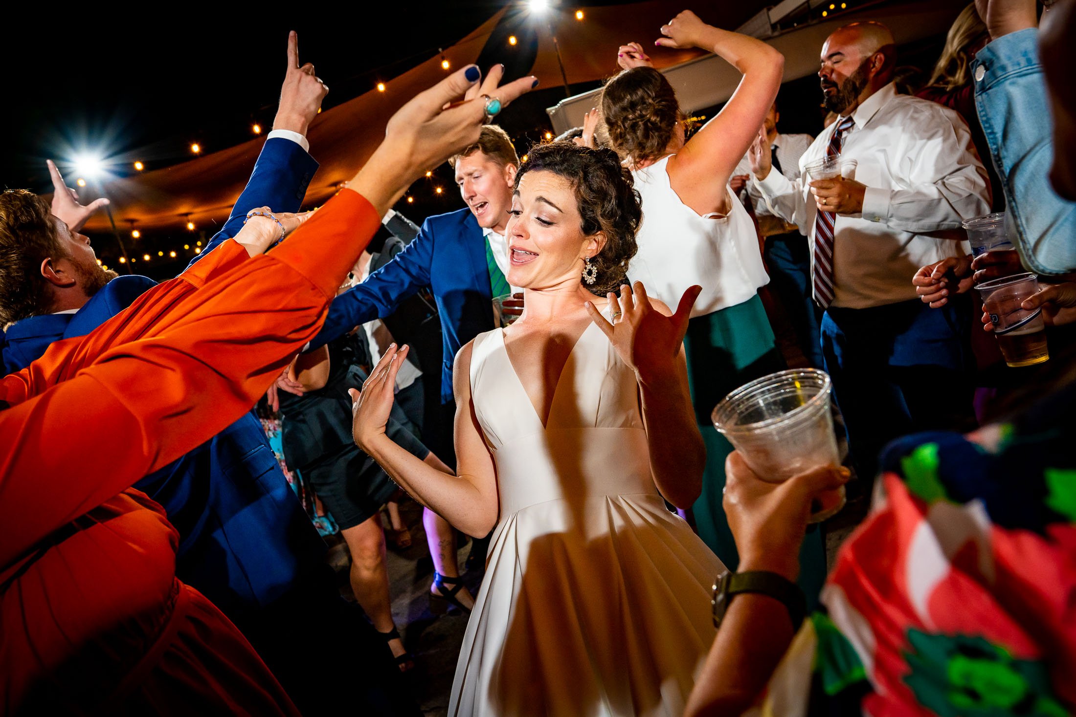 Guests dance to music on the outdoor patio under cafe lights during the wedding reception, wedding, wedding photos, wedding photography, wedding photographer, wedding inspiration, wedding photo inspiration, wedding portraits, wedding ceremony, wedding reception, mountain wedding, Catholic Church wedding, Catholic Church wedding photos, Catholic Church wedding photography, Catholic Church wedding photographer, Catholic Church wedding inspiration, Catholic Church wedding venue, Steamboat Springs wedding, Steamboat Springs wedding photos, Steamboat Springs wedding photography, Steamboat Springs wedding photographer, Colorado wedding, Colorado wedding photos, Colorado wedding photography, Colorado wedding photographer, Colorado mountain wedding, Colorado wedding inspiration