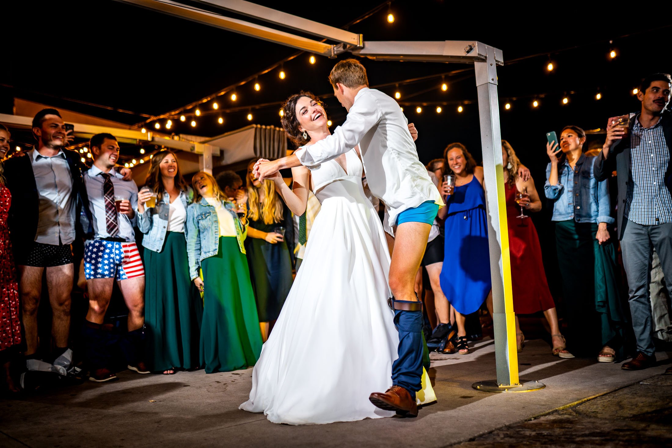Bride and groom dance together while groom is wearing only his boxers on the outdoor patio under cafe lights during the wedding reception, wedding, wedding photos, wedding photography, wedding photographer, wedding inspiration, wedding photo inspiration, wedding portraits, wedding ceremony, wedding reception, mountain wedding, Catholic Church wedding, Catholic Church wedding photos, Catholic Church wedding photography, Catholic Church wedding photographer, Catholic Church wedding inspiration, Catholic Church wedding venue, Steamboat Springs wedding, Steamboat Springs wedding photos, Steamboat Springs wedding photography, Steamboat Springs wedding photographer, Colorado wedding, Colorado wedding photos, Colorado wedding photography, Colorado wedding photographer, Colorado mountain wedding, Colorado wedding inspiration