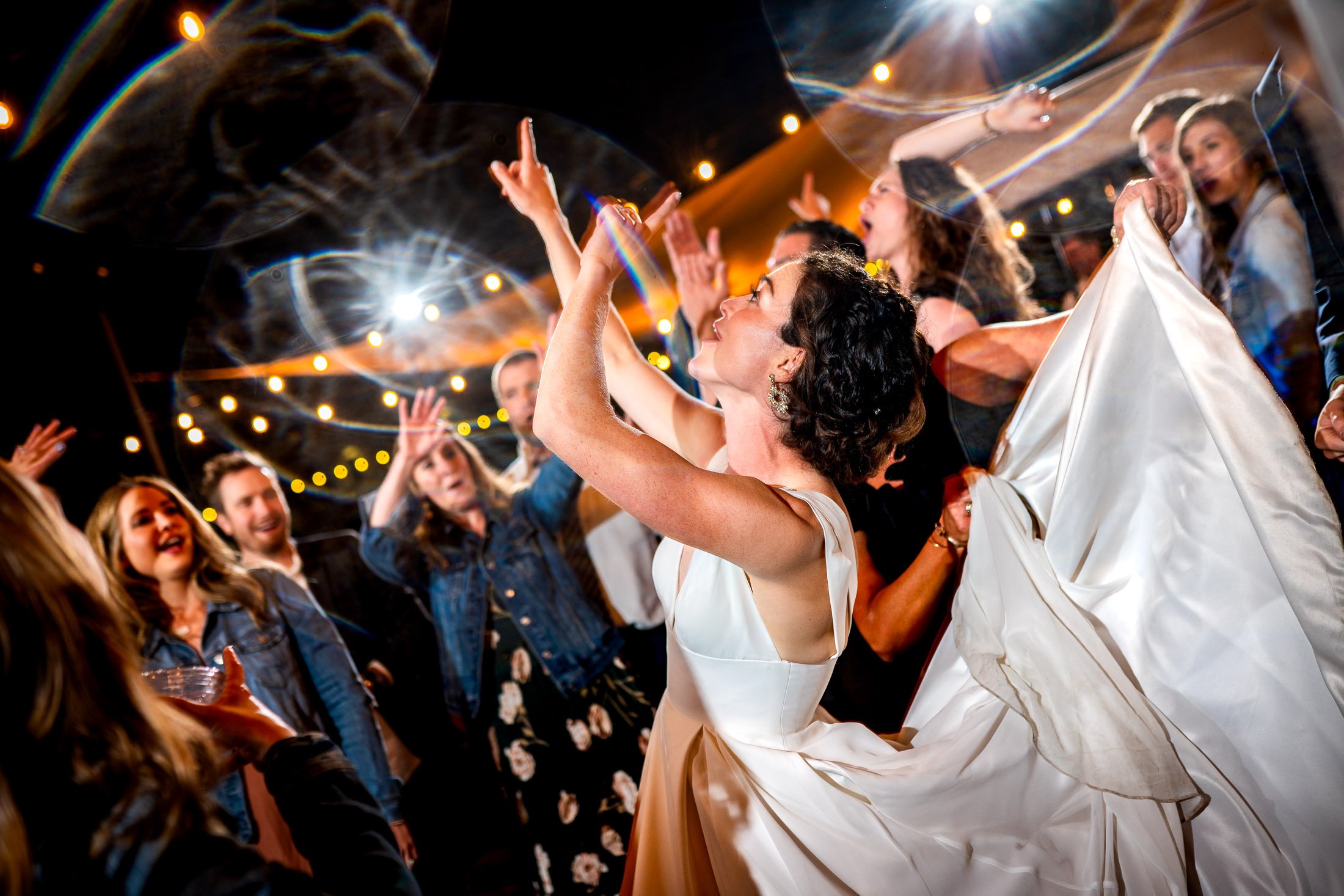 Guests dance to music on the outdoor patio under cafe lights during the wedding reception, wedding, wedding photos, wedding photography, wedding photographer, wedding inspiration, wedding photo inspiration, wedding portraits, wedding ceremony, wedding reception, mountain wedding, Catholic Church wedding, Catholic Church wedding photos, Catholic Church wedding photography, Catholic Church wedding photographer, Catholic Church wedding inspiration, Catholic Church wedding venue, Steamboat Springs wedding, Steamboat Springs wedding photos, Steamboat Springs wedding photography, Steamboat Springs wedding photographer, Colorado wedding, Colorado wedding photos, Colorado wedding photography, Colorado wedding photographer, Colorado mountain wedding, Colorado wedding inspiration