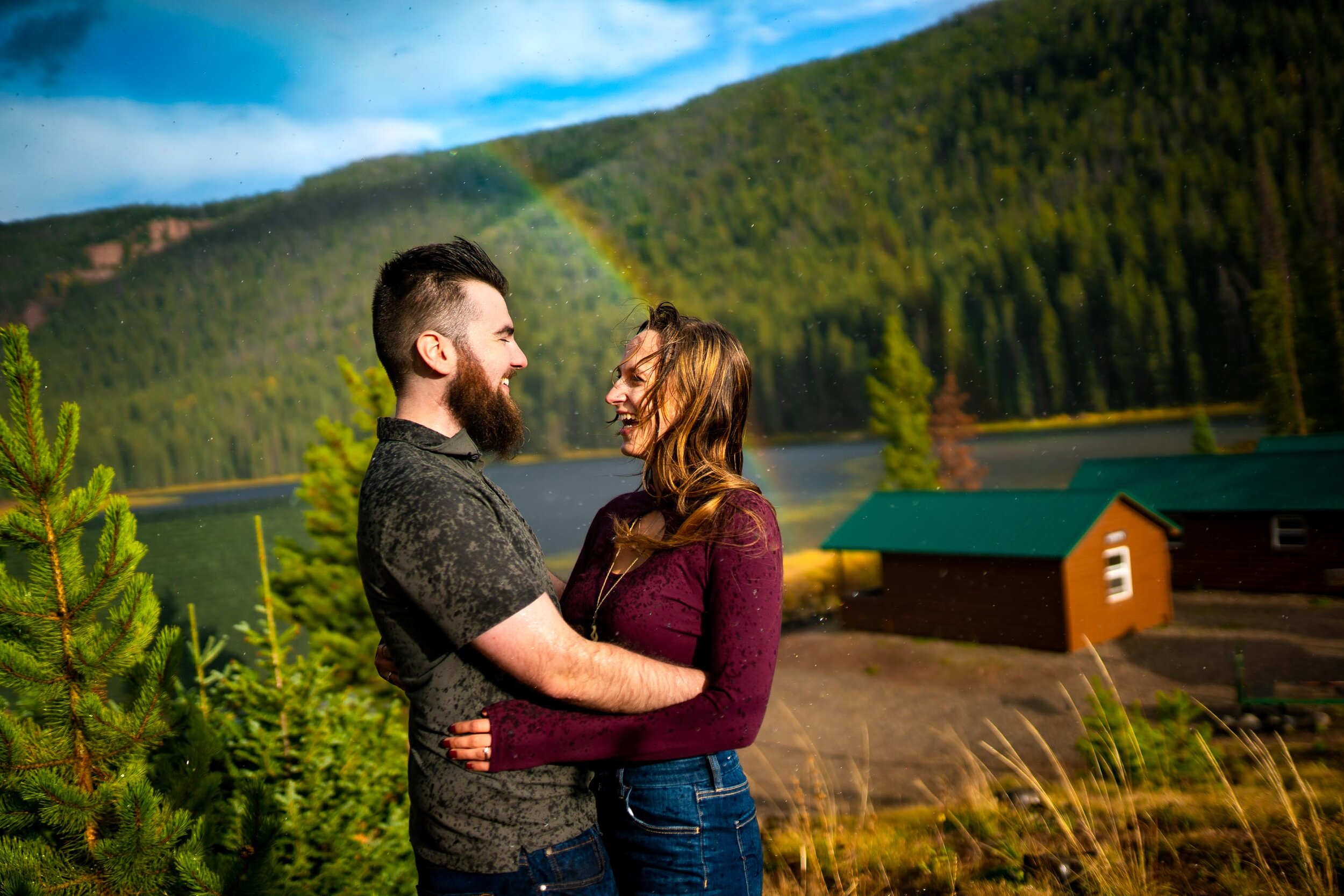 Engaged couple embraces for a portrait during a rainstorm with a double rainbow behind them arching over Piney Lake, Engagement Session, Engagement Photos, Engagement Photos Inspiration, Engagement Photography, Engagement Photographer, Fall Engagement Photos, Mountain Engagement Photos, Piney River Ranch engagement photos, Vail engagement session, Vail engagement photos, Vail engagement photography, Vail engagement photographer, Vail engagement inspiration, Colorado engagement session, Colorado engagement photos, Colorado engagement photography, Colorado engagement photographer, Colorado engagement inspiration