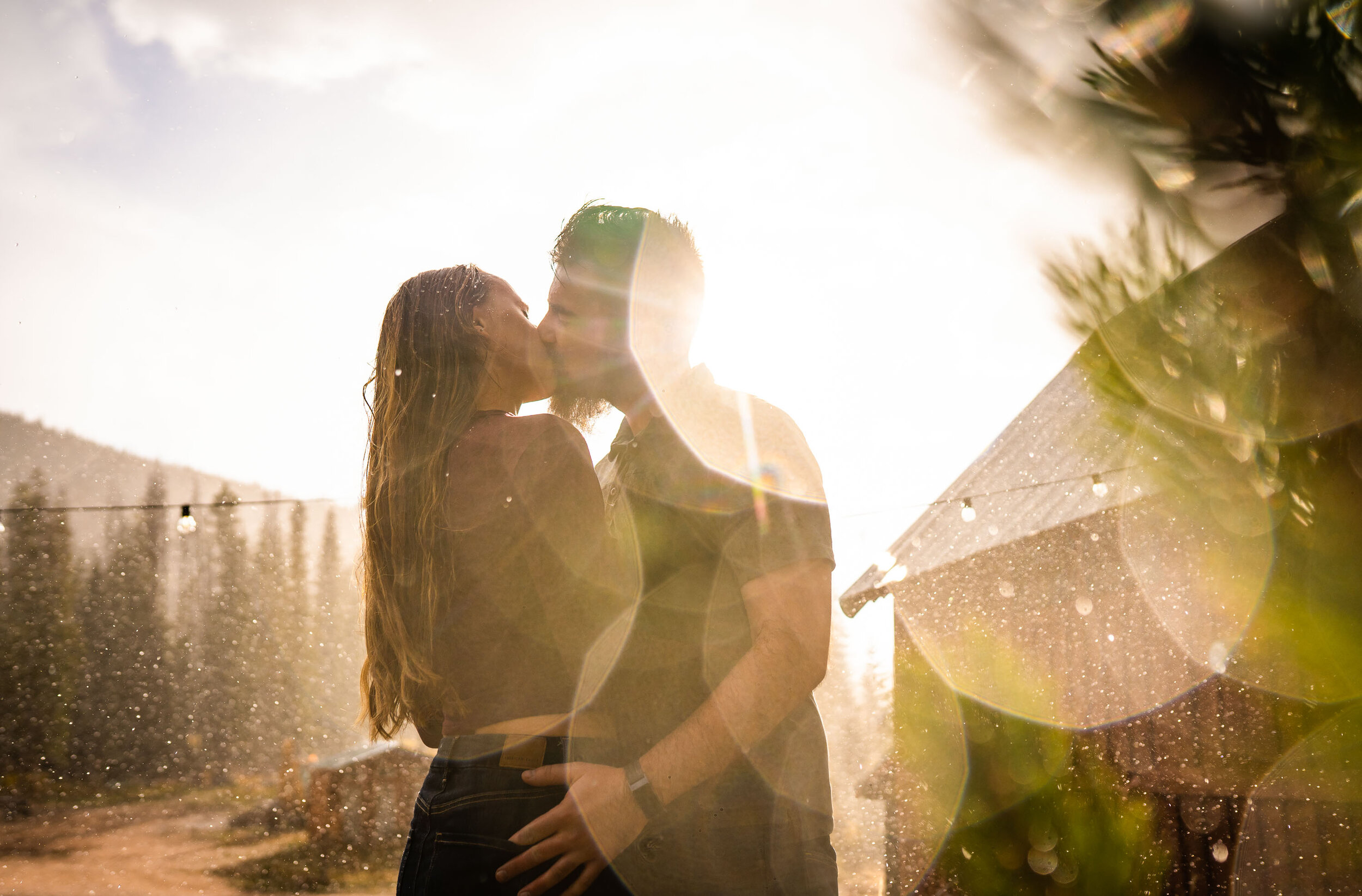 Engaged couple embraces for a portrait during a rainstorm with a double rainbow behind them arching over Piney Lake, Engagement Session, Engagement Photos, Engagement Photos Inspiration, Engagement Photography, Engagement Photographer, Fall Engagement Photos, Mountain Engagement Photos, Piney River Ranch engagement photos, Vail engagement session, Vail engagement photos, Vail engagement photography, Vail engagement photographer, Vail engagement inspiration, Colorado engagement session, Colorado engagement photos, Colorado engagement photography, Colorado engagement photographer, Colorado engagement inspiration