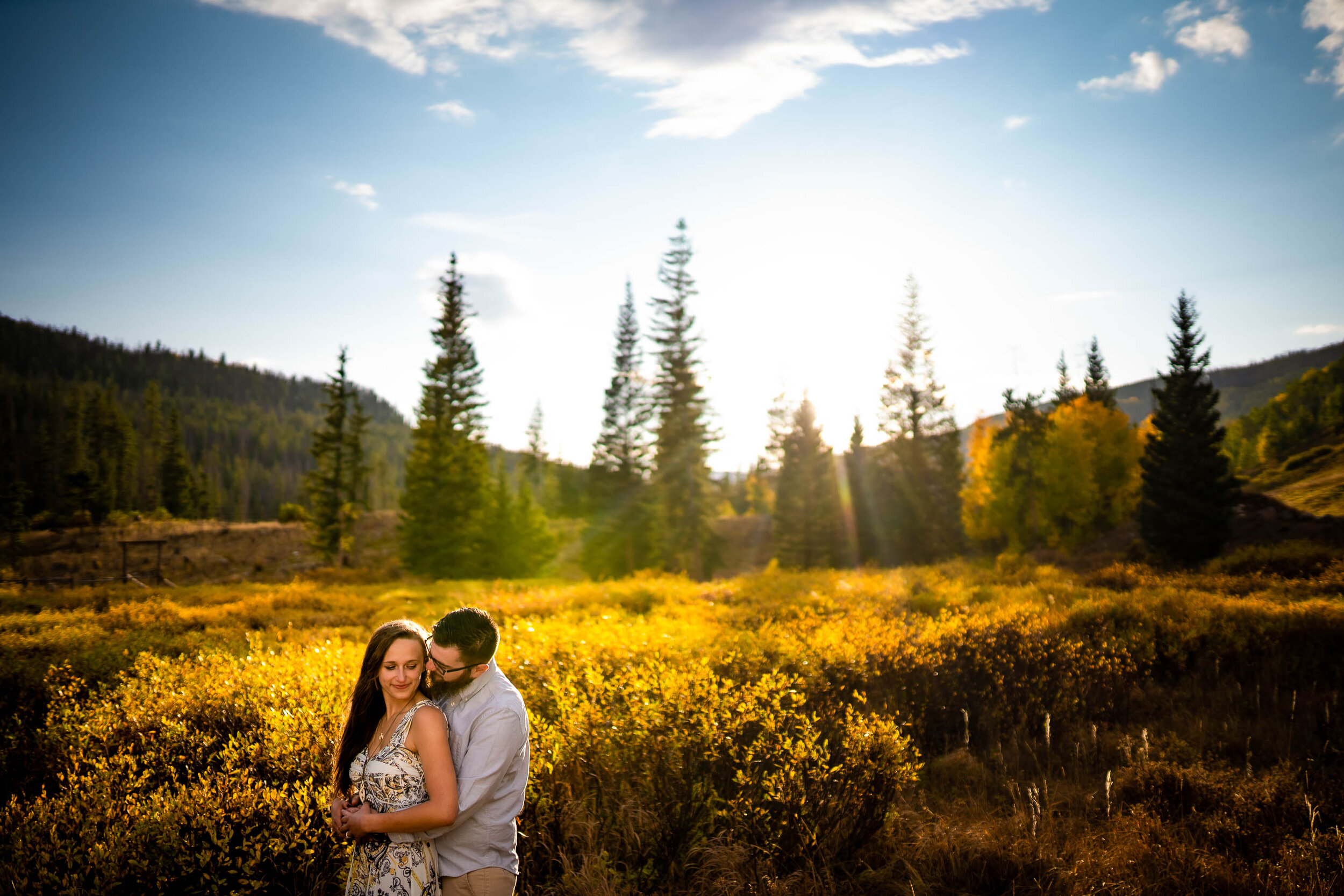 Engaged couple embraces for a portrait in a field of gold during golden hour in the peak of the fall season with foliage all around, Engagement Session, Engagement Photos, Engagement Photos Inspiration, Engagement Photography, Engagement Photographer, Fall Engagement Photos, Mountain Engagement Photos, Piney River Ranch engagement photos, Vail engagement session, Vail engagement photos, Vail engagement photography, Vail engagement photographer, Vail engagement inspiration, Colorado engagement session, Colorado engagement photos, Colorado engagement photography, Colorado engagement photographer, Colorado engagement inspiration