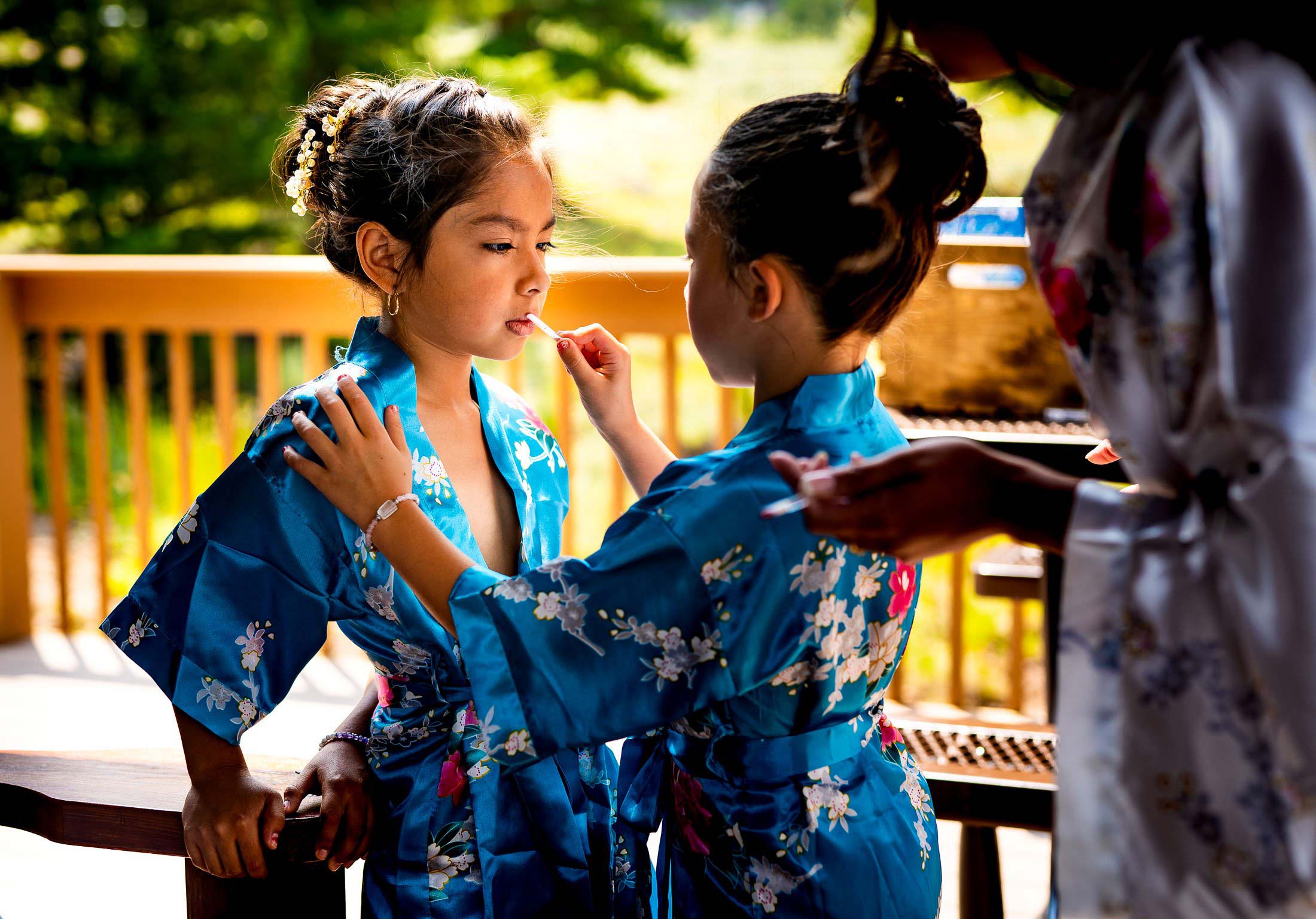 Kids do each other's make-up in the on the deck of the bridal suite cabin, wedding, wedding photos, wedding photography, wedding photographer, wedding inspiration, wedding photo inspiration, mountain wedding, YMCA of the Rockies wedding, YMCA of the Rockies wedding photos, YMCA of the Rockies wedding photography, YMCA of the Rockies wedding photographer, YMCA of the Rockies wedding inspiration, YMCA of the Rockies wedding venue, Estes Park wedding, Estes Park wedding photos, Estes Park wedding photography, Estes Park wedding photographer, Colorado wedding, Colorado wedding photos, Colorado wedding photography, Colorado wedding photographer, Colorado mountain wedding, Colorado wedding inspiration