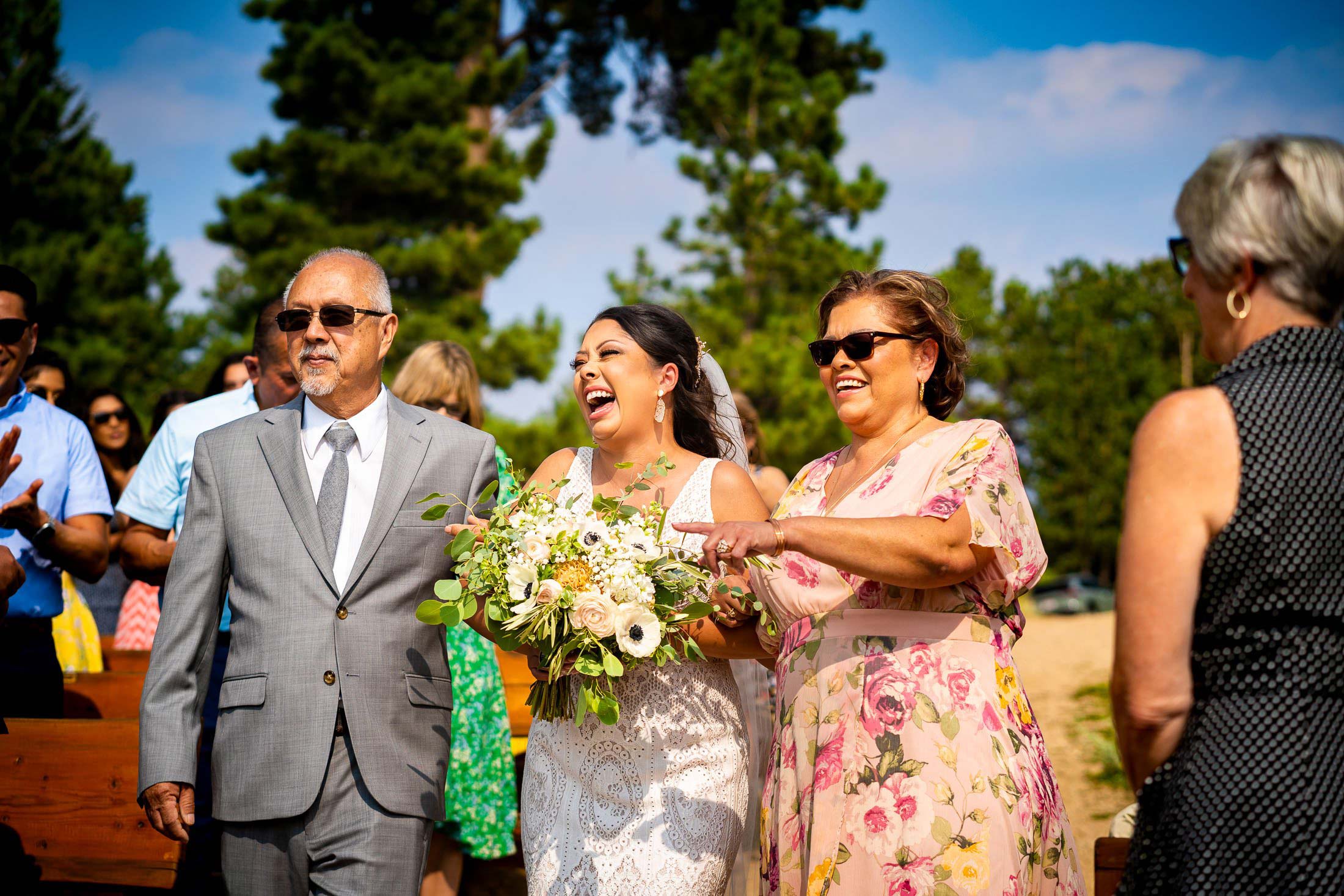 The bride walks down the aisle during the processional at their wedding ceremony in the mountains, wedding photos, wedding photography, wedding photographer, wedding inspiration, wedding photo inspiration, mountain wedding, YMCA of the Rockies wedding, YMCA of the Rockies wedding photos, YMCA of the Rockies wedding photography, YMCA of the Rockies wedding photographer, YMCA of the Rockies wedding inspiration, YMCA of the Rockies wedding venue, Estes Park wedding, Estes Park wedding photos, Estes Park wedding photography, Estes Park wedding photographer, Colorado wedding, Colorado wedding photos, Colorado wedding photography, Colorado wedding photographer, Colorado mountain wedding, Colorado wedding inspiration