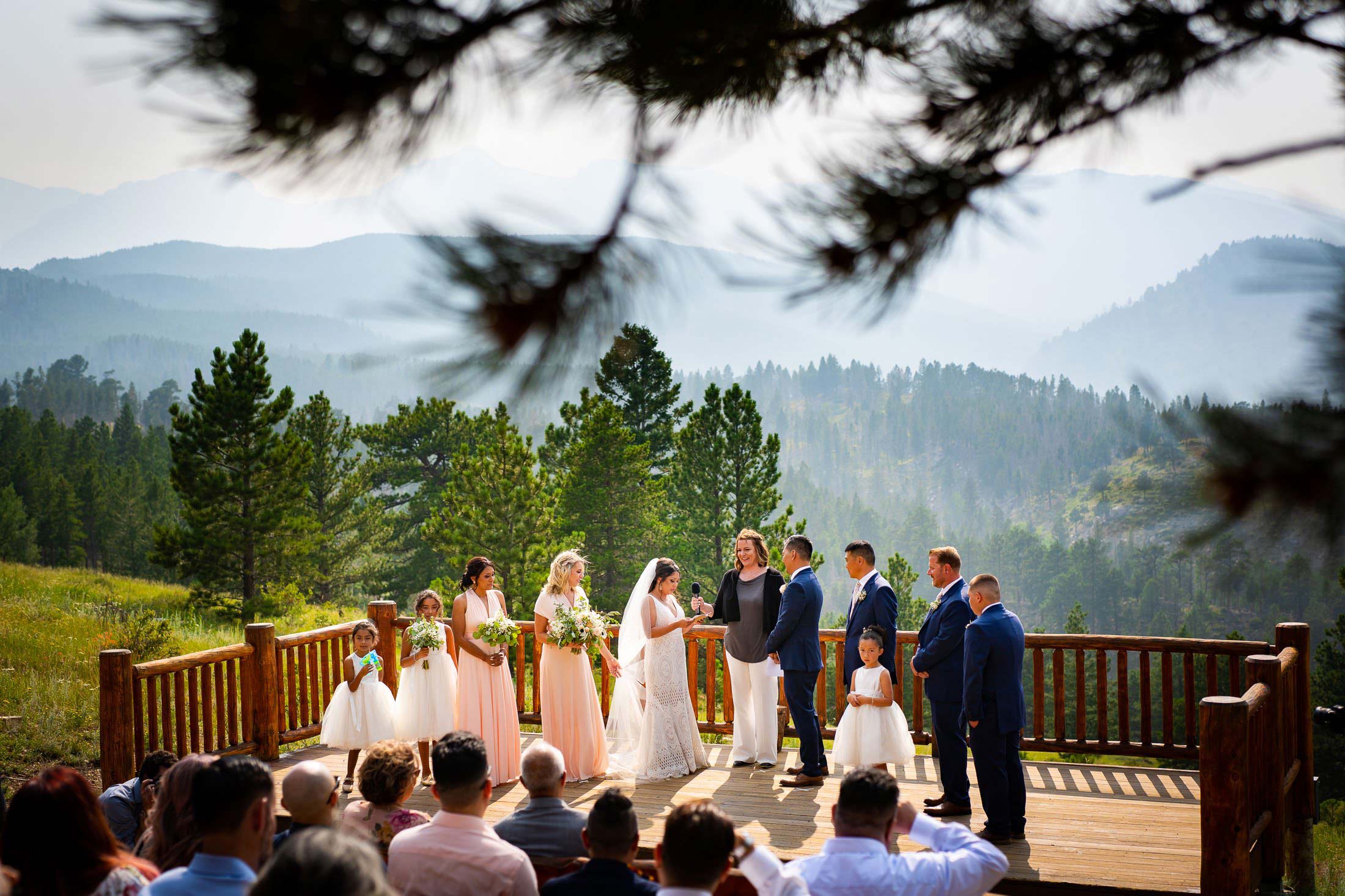 Bride reads her wedding vows during their wedding ceremony in the mountains as their wedding party stands by their side, wedding photos, wedding photography, wedding photographer, wedding inspiration, wedding photo inspiration, mountain wedding, YMCA of the Rockies wedding, YMCA of the Rockies wedding photos, YMCA of the Rockies wedding photography, YMCA of the Rockies wedding photographer, YMCA of the Rockies wedding inspiration, YMCA of the Rockies wedding venue, Estes Park wedding, Estes Park wedding photos, Estes Park wedding photography, Estes Park wedding photographer, Colorado wedding, Colorado wedding photos, Colorado wedding photography, Colorado wedding photographer, Colorado mountain wedding, Colorado wedding inspiration