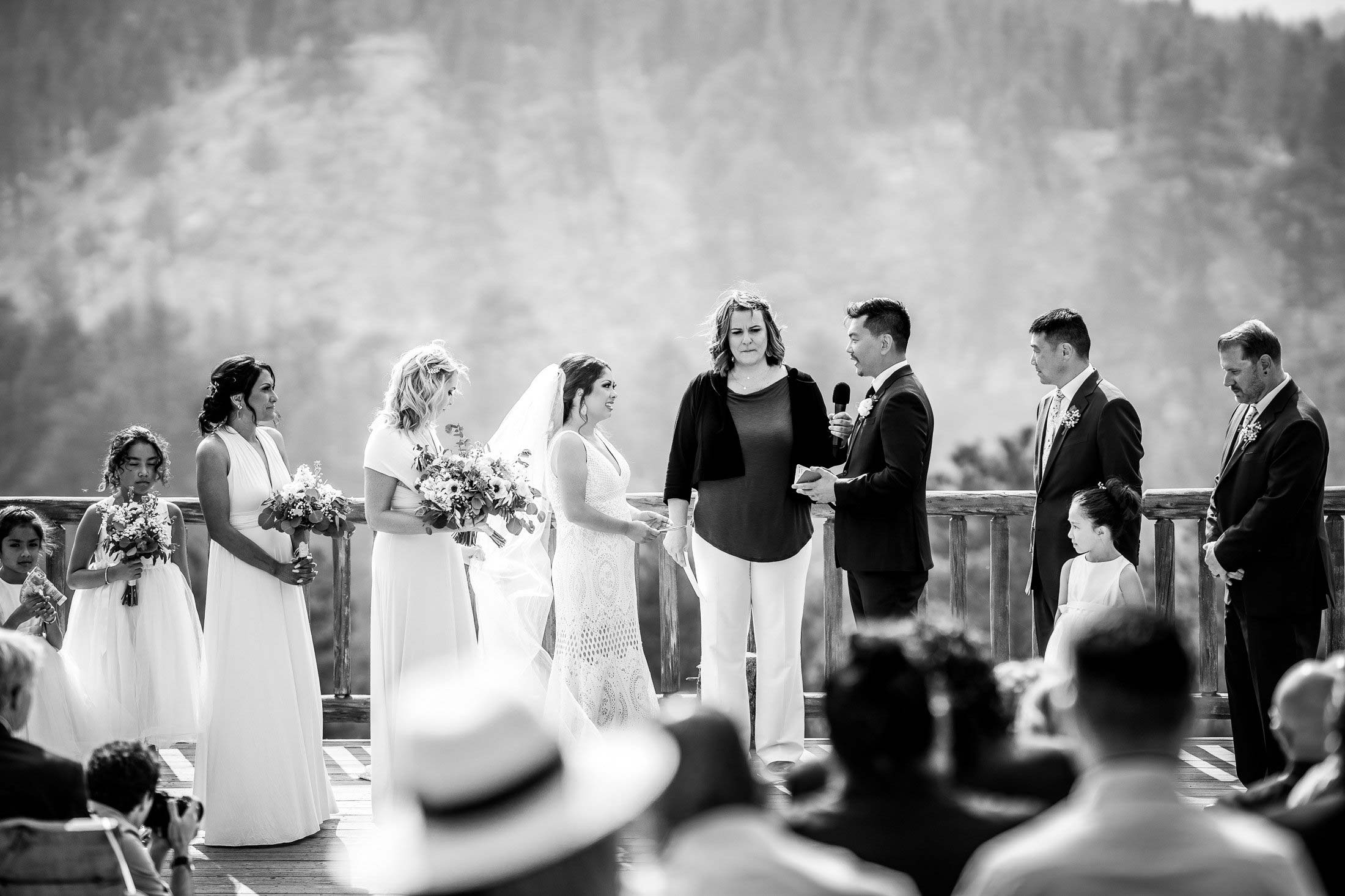 Groom reads his wedding vows during their wedding ceremony in the mountains as their wedding party stands by their side, wedding photos, wedding photography, wedding photographer, wedding inspiration, wedding photo inspiration, mountain wedding, YMCA of the Rockies wedding, YMCA of the Rockies wedding photos, YMCA of the Rockies wedding photography, YMCA of the Rockies wedding photographer, YMCA of the Rockies wedding inspiration, YMCA of the Rockies wedding venue, Estes Park wedding, Estes Park wedding photos, Estes Park wedding photography, Estes Park wedding photographer, Colorado wedding, Colorado wedding photos, Colorado wedding photography, Colorado wedding photographer, Colorado mountain wedding, Colorado wedding inspiration