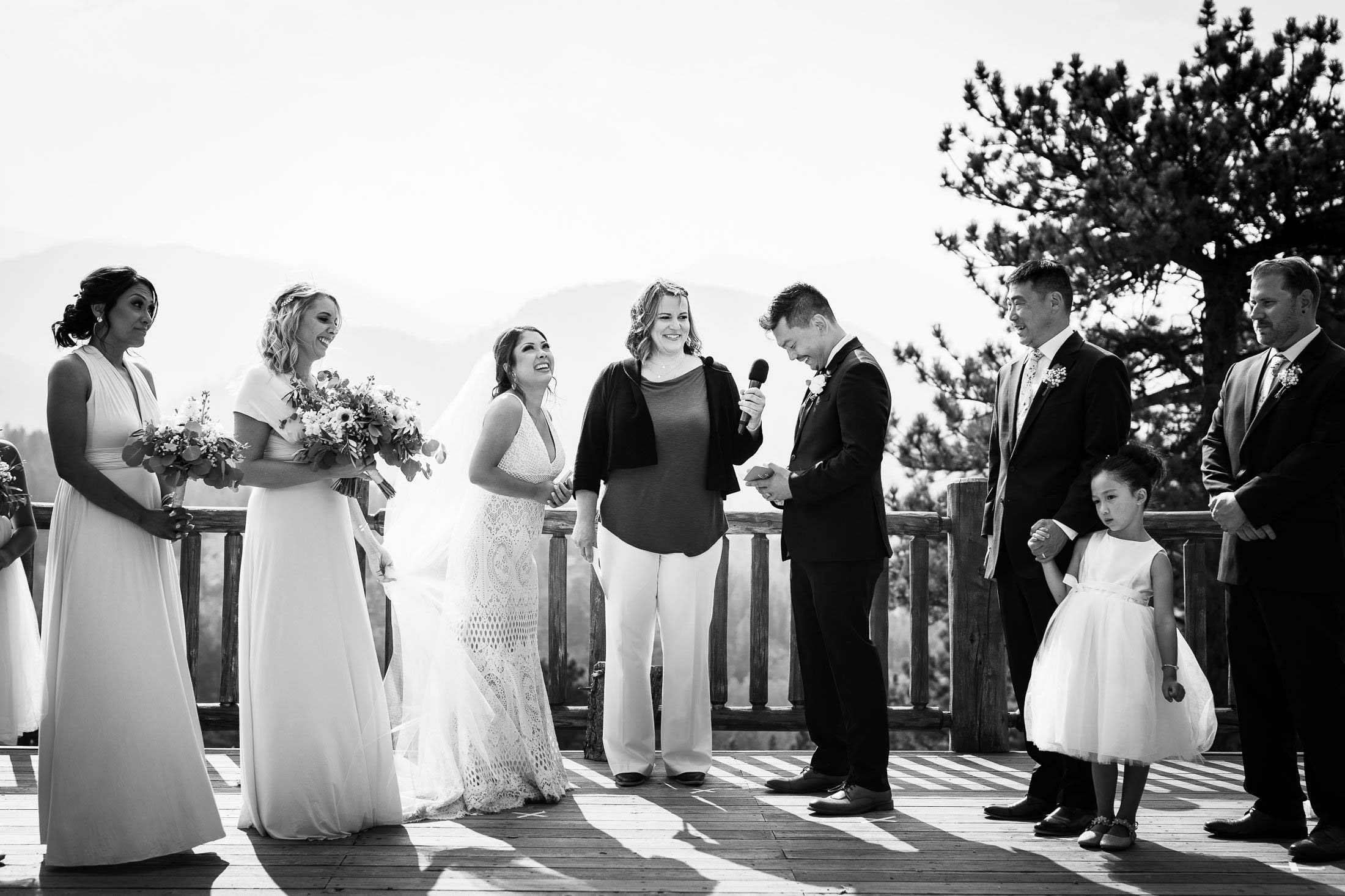 Groom reads his wedding vows during their wedding ceremony in the mountains as their wedding party stands by their side, wedding photos, wedding photography, wedding photographer, wedding inspiration, wedding photo inspiration, mountain wedding, YMCA of the Rockies wedding, YMCA of the Rockies wedding photos, YMCA of the Rockies wedding photography, YMCA of the Rockies wedding photographer, YMCA of the Rockies wedding inspiration, YMCA of the Rockies wedding venue, Estes Park wedding, Estes Park wedding photos, Estes Park wedding photography, Estes Park wedding photographer, Colorado wedding, Colorado wedding photos, Colorado wedding photography, Colorado wedding photographer, Colorado mountain wedding, Colorado wedding inspiration