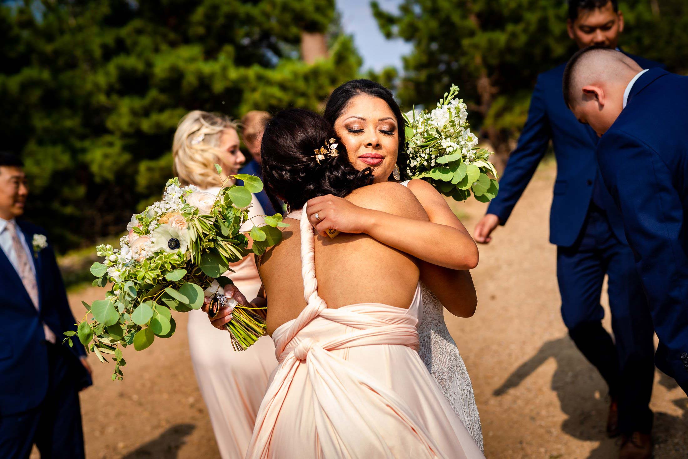 Bride hugs a bridesmaid after their wedding ceremony, wedding photos, wedding photography, wedding photographer, wedding inspiration, wedding photo inspiration, mountain wedding, YMCA of the Rockies wedding, YMCA of the Rockies wedding photos, YMCA of the Rockies wedding photography, YMCA of the Rockies wedding photographer, YMCA of the Rockies wedding inspiration, YMCA of the Rockies wedding venue, Estes Park wedding, Estes Park wedding photos, Estes Park wedding photography, Estes Park wedding photographer, Colorado wedding, Colorado wedding photos, Colorado wedding photography, Colorado wedding photographer, Colorado mountain wedding, Colorado wedding inspiration