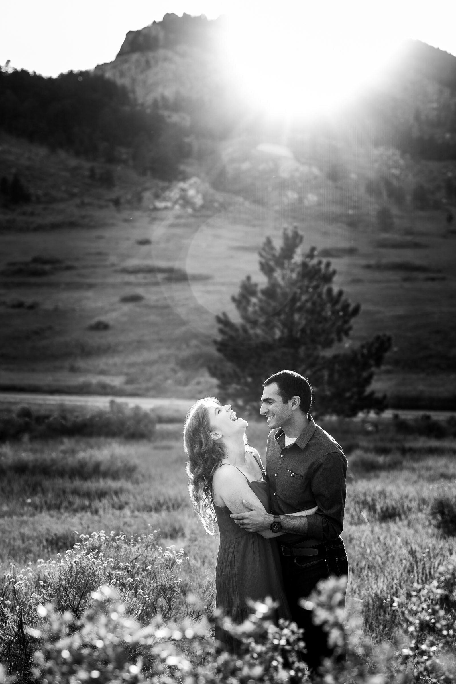 Engaged couple embraces in a luscious green landscape of rolling foothills during golden hour, Engagement Photos, Engagement Photo Inspiration, Engagement Photography, Engagement Photographer, Spring Engagement Photos, Fort Collins Engagement Photos, Fort Collins engagement photos, Fort Collins engagement photography, Fort Collins engagement photographer, Colorado engagement photos, Colorado engagement photography, Colorado engagement inspiration, Horsetooth Reservoir Engagement
