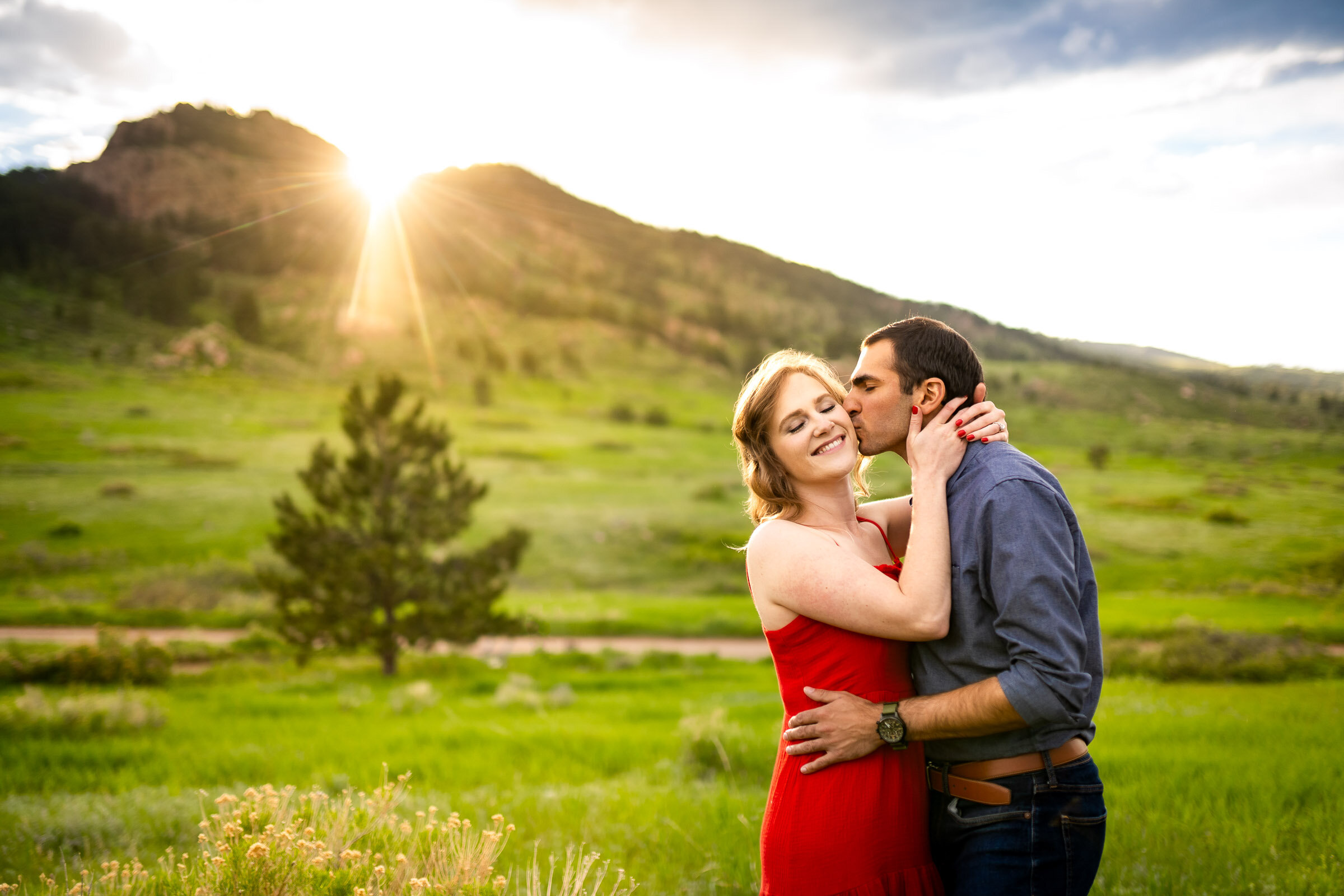 Engaged couple embraces in a luscious green landscape of rolling foothills during golden hour, Engagement Photos, Engagement Photo Inspiration, Engagement Photography, Engagement Photographer, Spring Engagement Photos, Fort Collins Engagement Photos, Fort Collins engagement photos, Fort Collins engagement photography, Fort Collins engagement photographer, Colorado engagement photos, Colorado engagement photography, Colorado engagement inspiration, Horsetooth Reservoir Engagement
