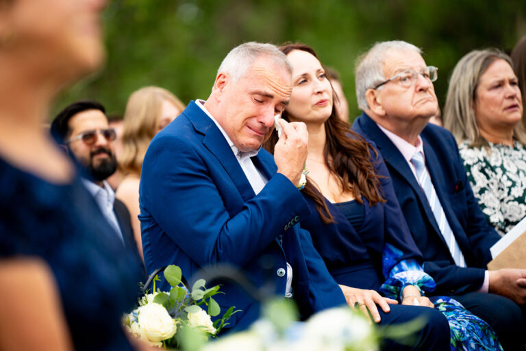 The father of a bride tears up during her wedding ceremony