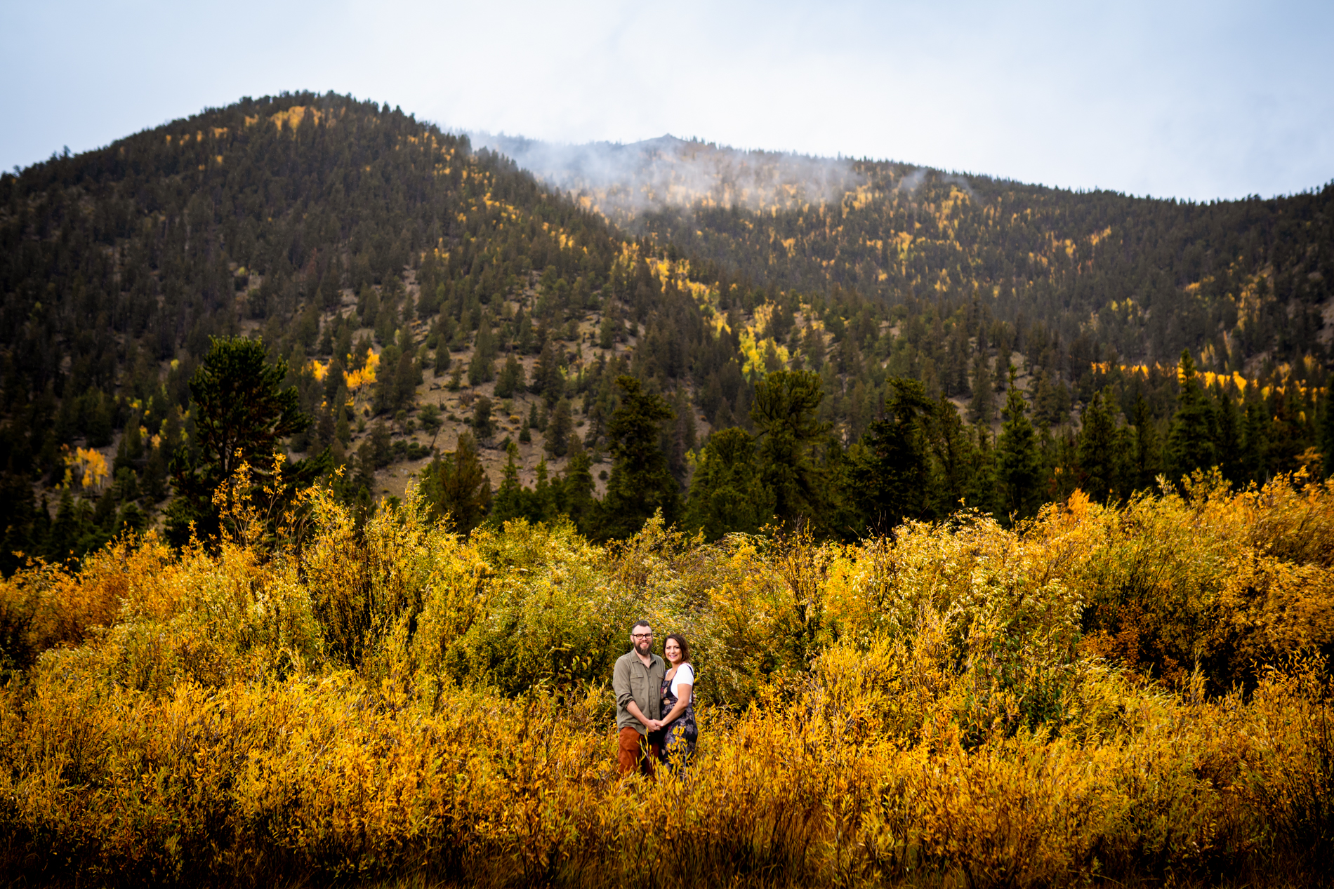 Cottonwood Pass Engagement Photos in Buena Vista with fall foliage, mountains and a winter blizzard