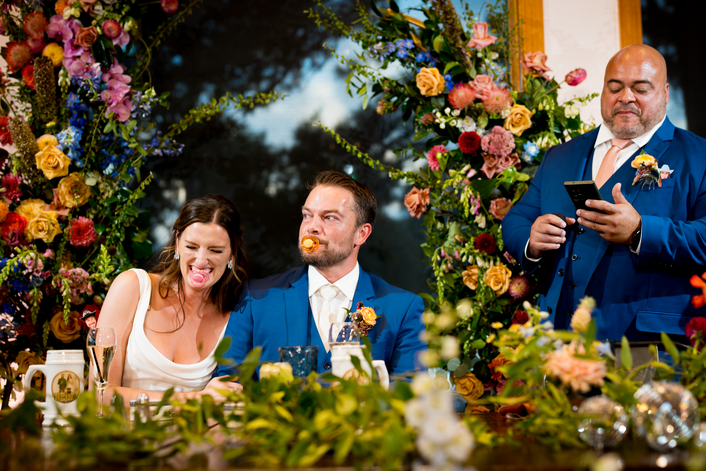 Bride and groom listen to speeches and toasts