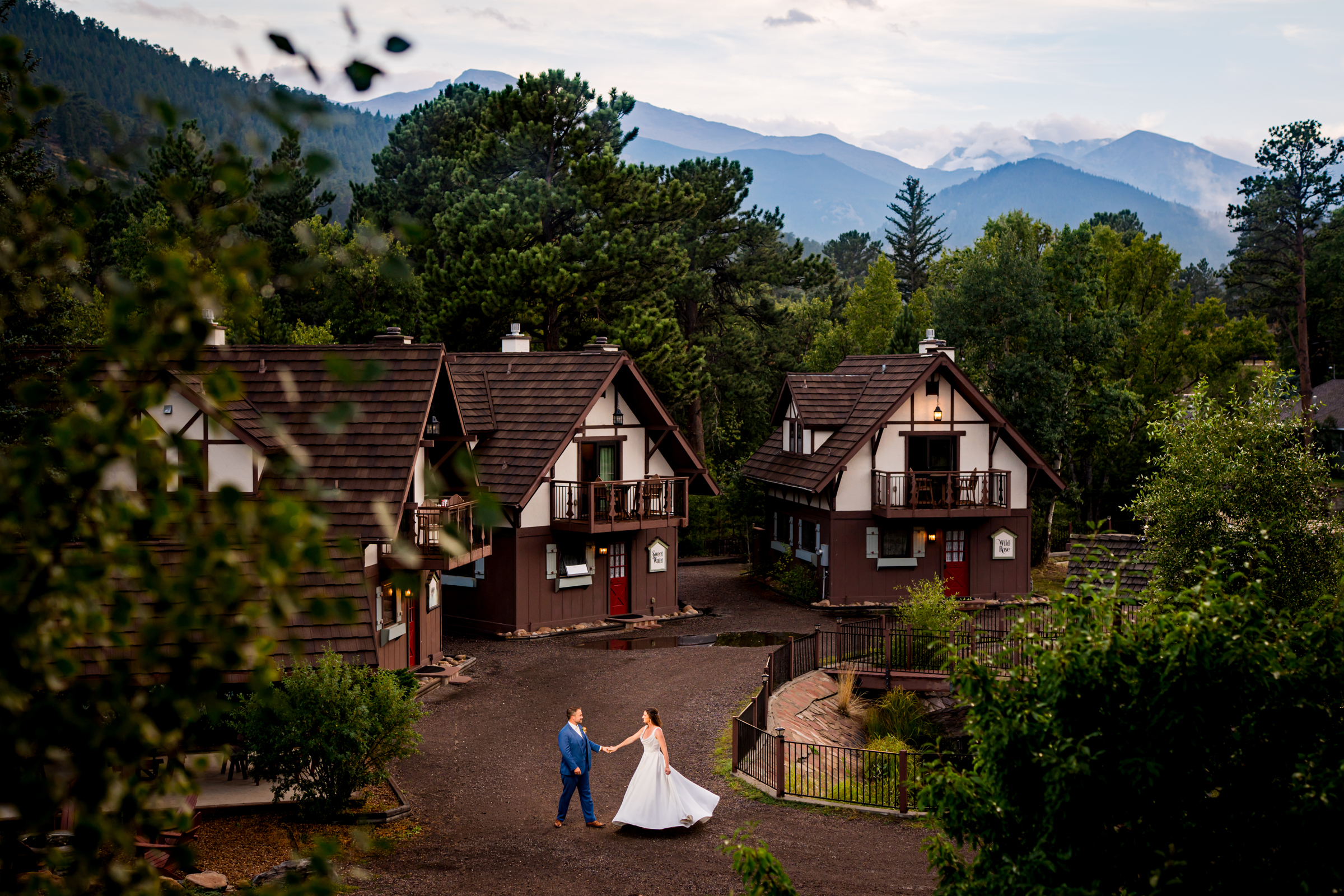 Portrait of bride and groom surrounding by cabins and the rocky mountains in the distance