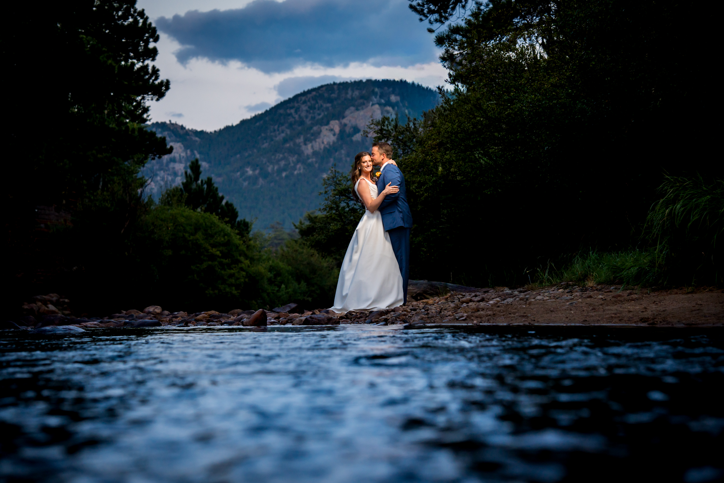 Portrait of the bride and groom by the river during blue hour