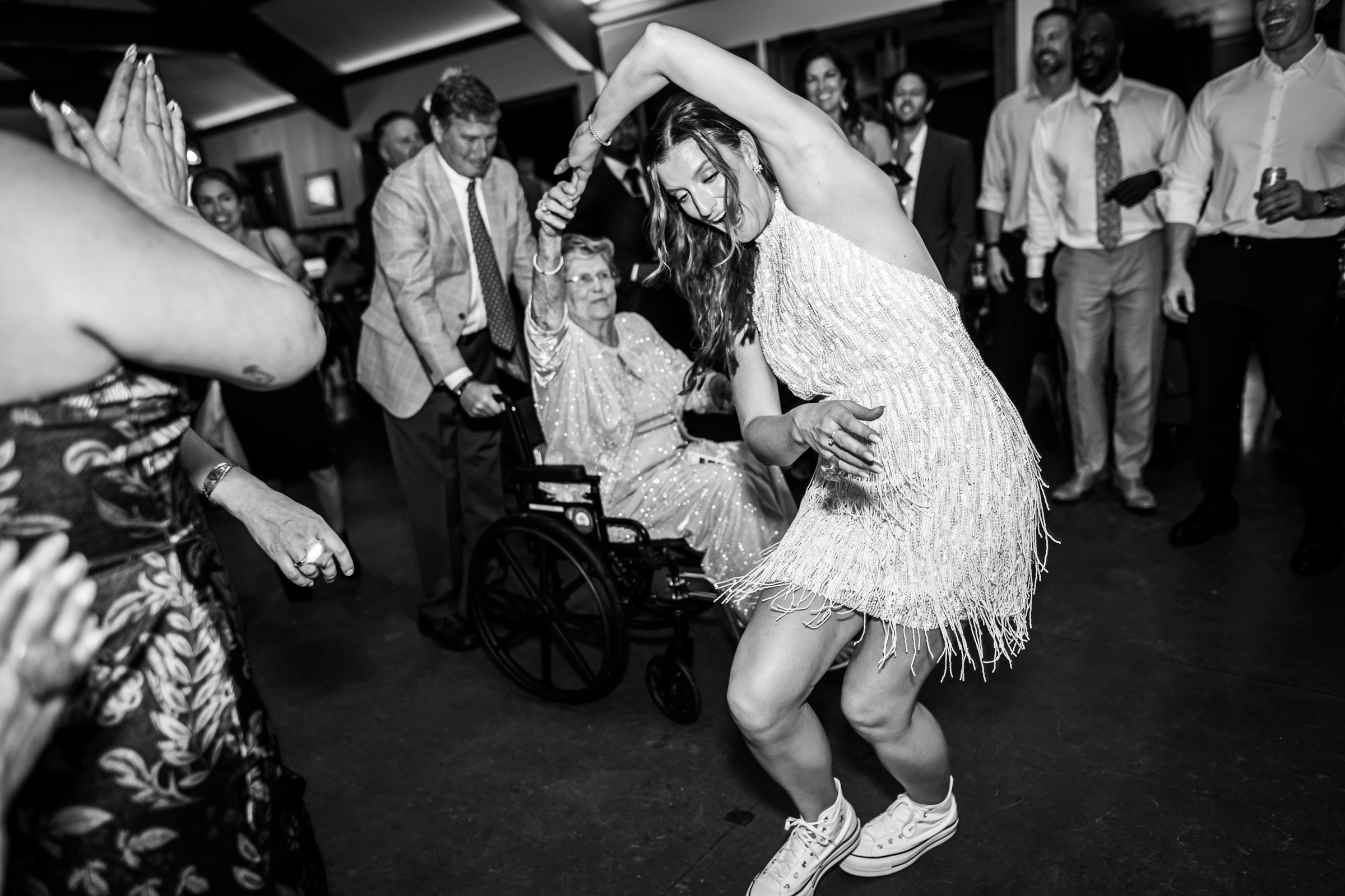 Bride dances with her grandmother in a wheelchair on the dance floor during the wedding reception