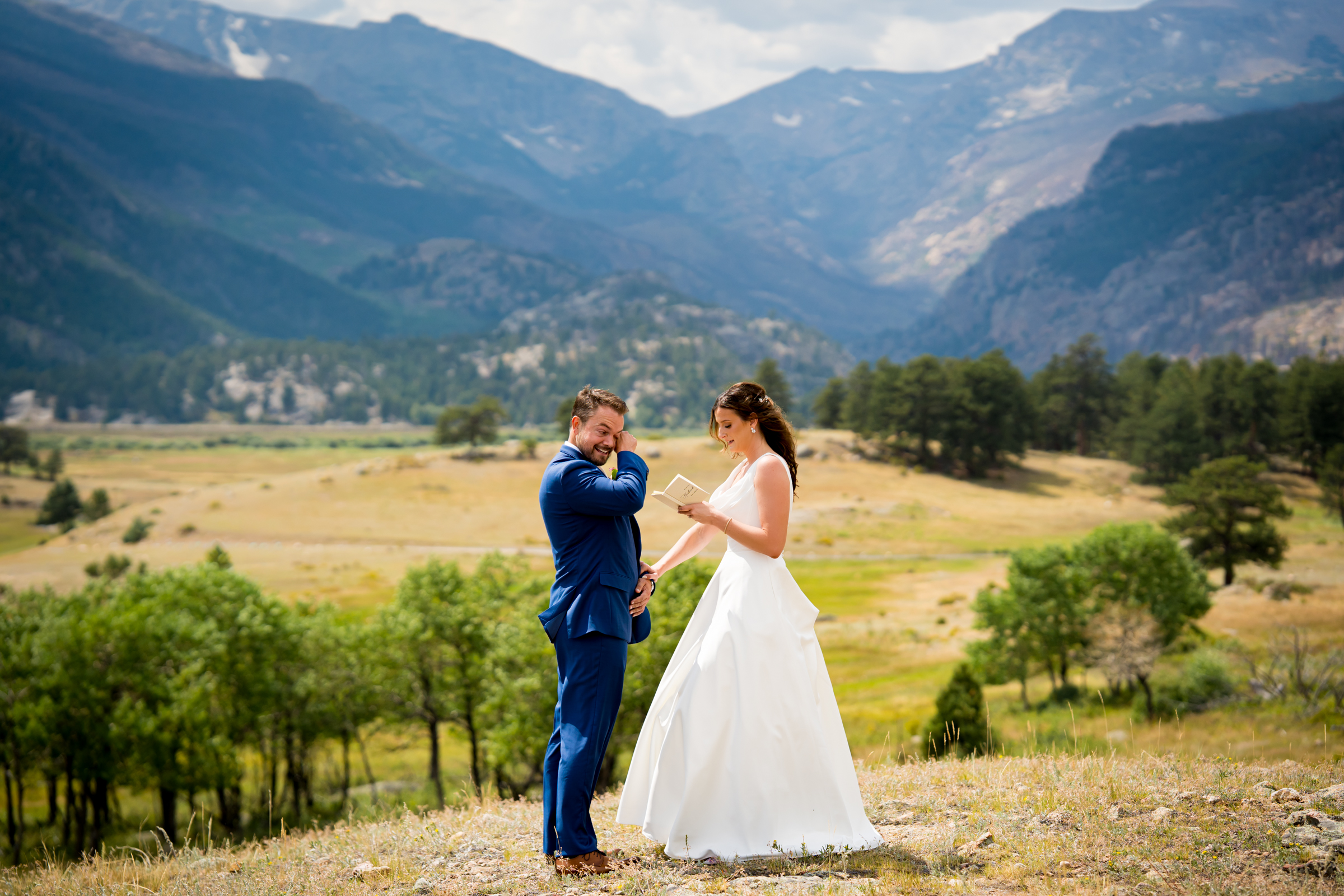 Bride and groom share private vows at Rocky Mountain National Park with the mountains and meadows in the distance