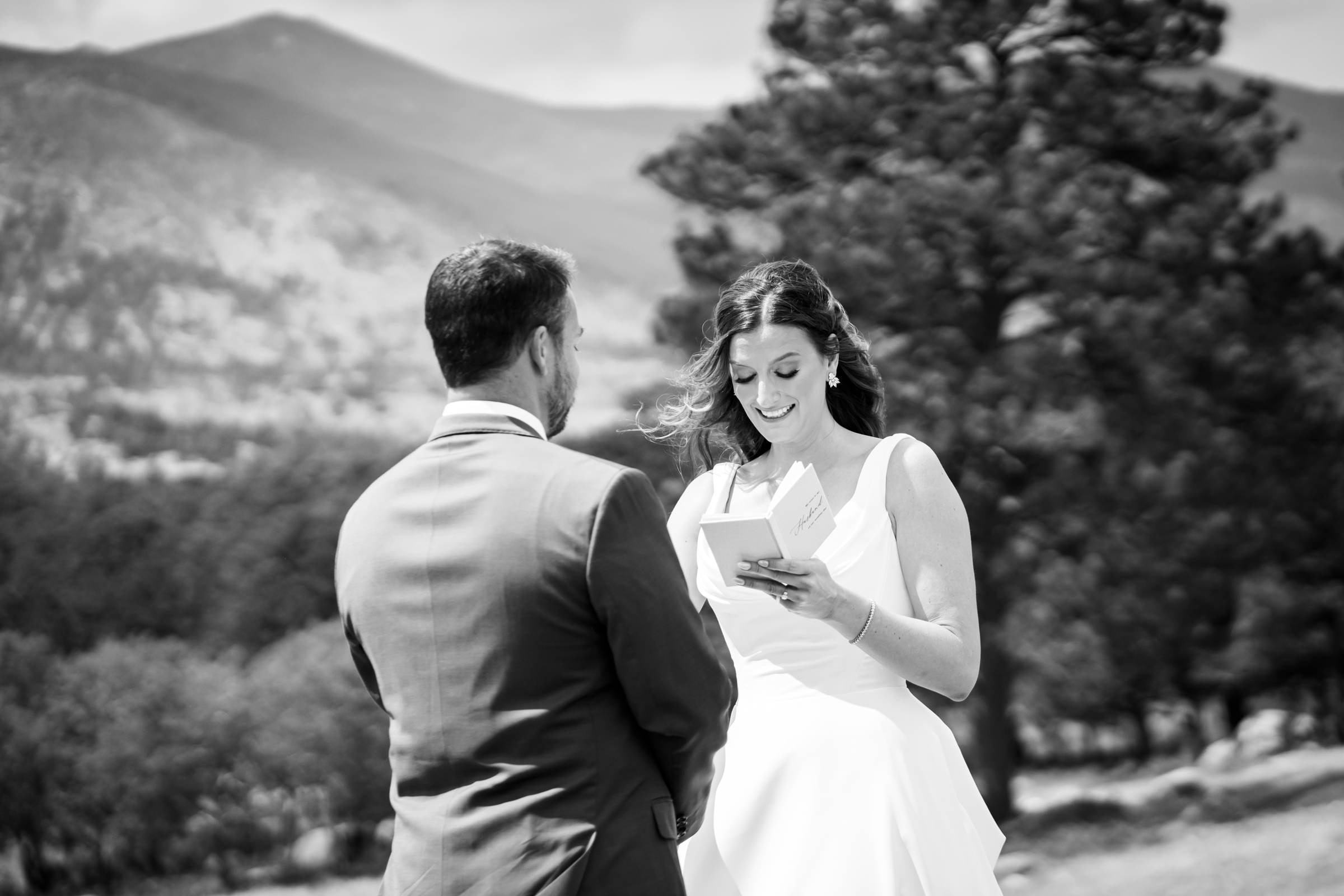 Bride and groom share private vows at Rocky Mountain National Park with the mountains and meadows in the distance
