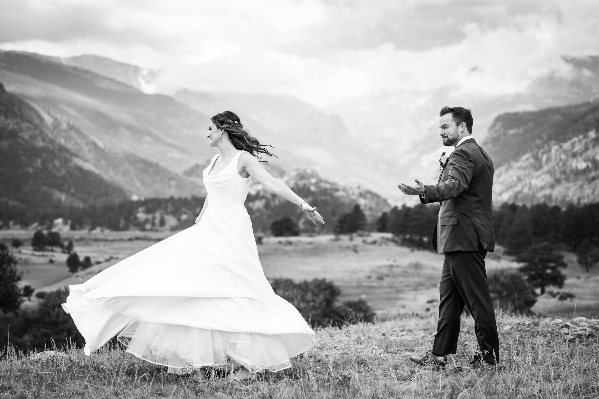 Bride and groom pose for newlywed portraits at Rocky Mountain National Park with the mountains and meadows in the distance