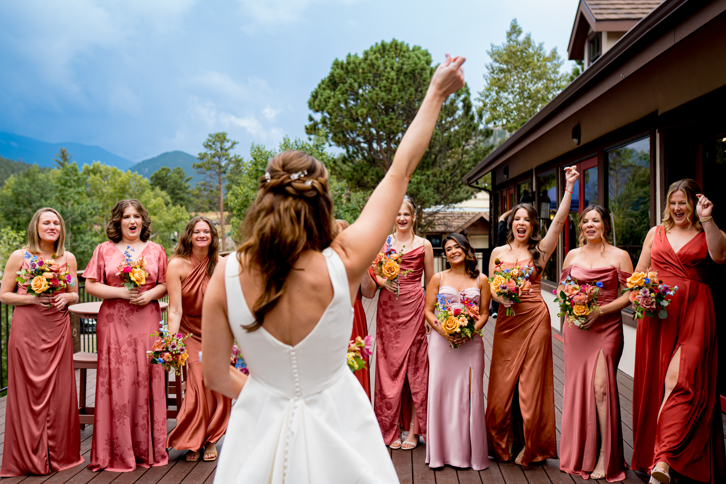 Bride has a first look with her bridesmaids on a balcony before the wedding ceremony