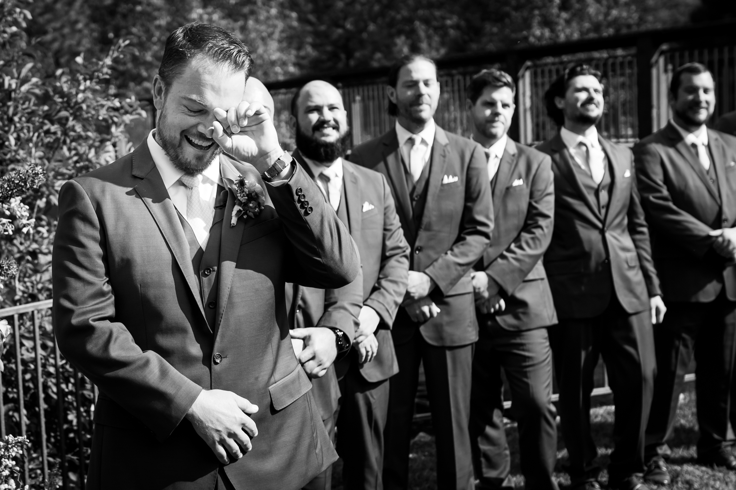 Groom sheds a tear and laughs as the bride walks down the aisle during the processional