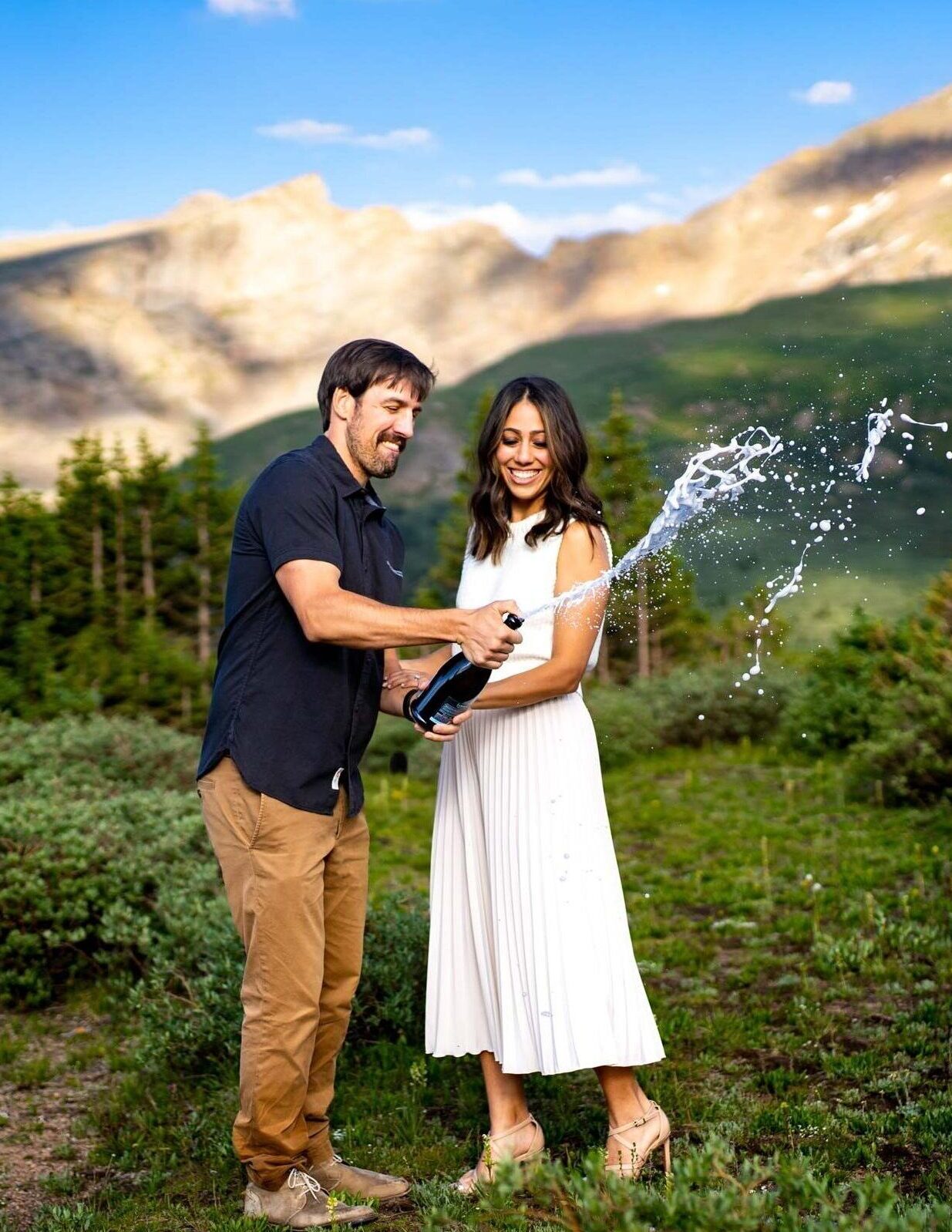 Colorado Engagement Photos at Guanella Pass, newlywed couple pops a bottle of champagne with the mountains in the background.